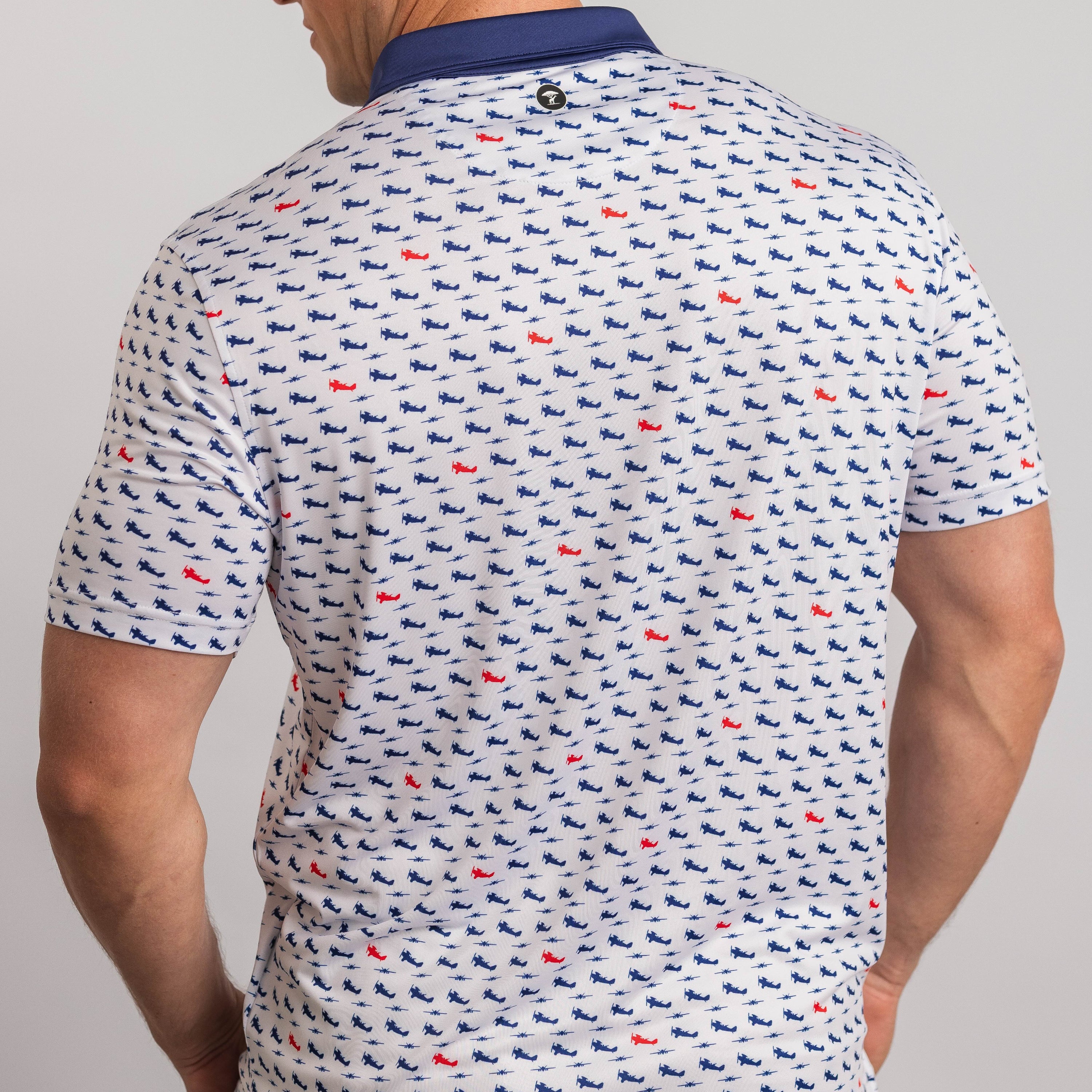Man wearing a patterned polo shirt with small designs on a plain background
