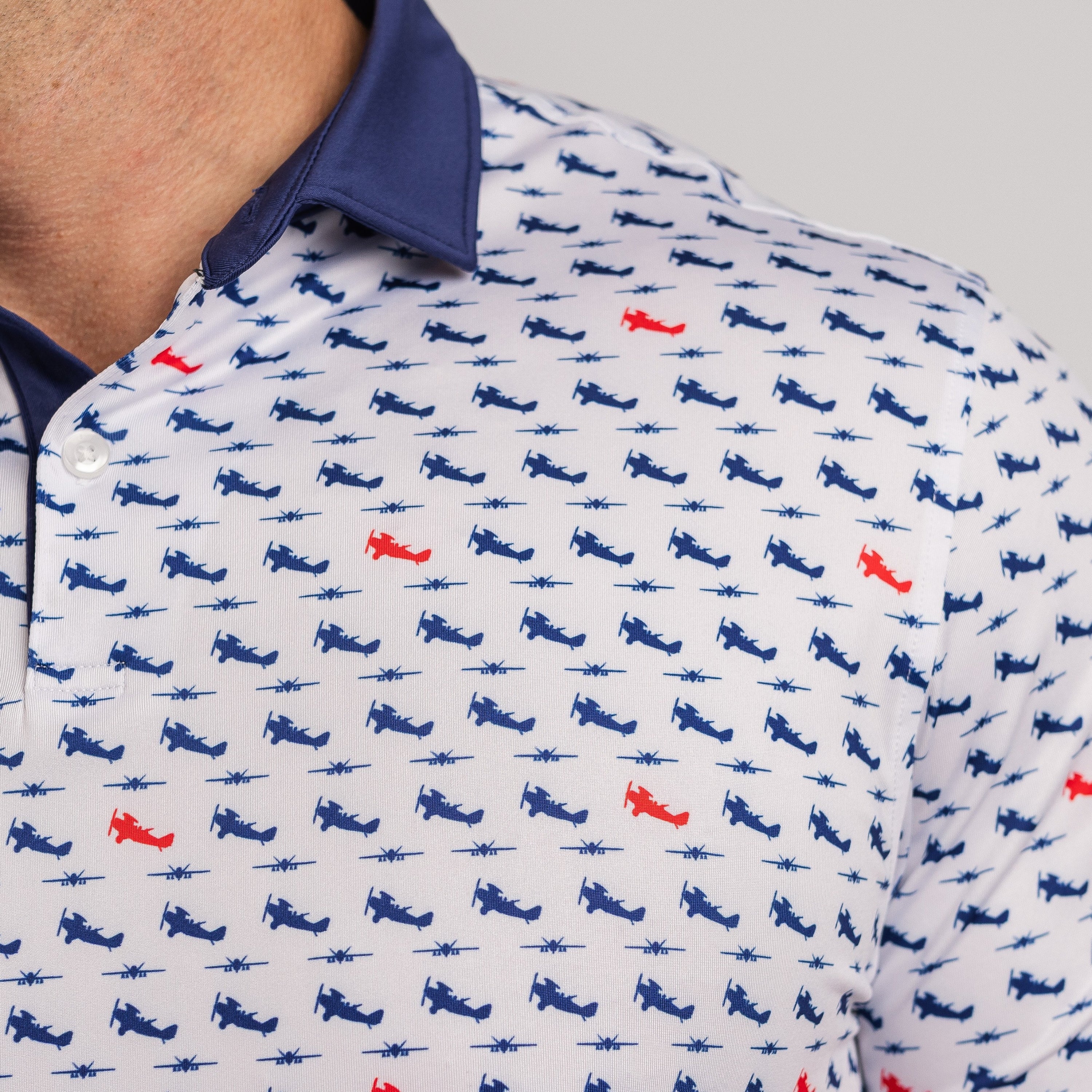 Close-up of a patterned shirt with small airplane designs on a white background