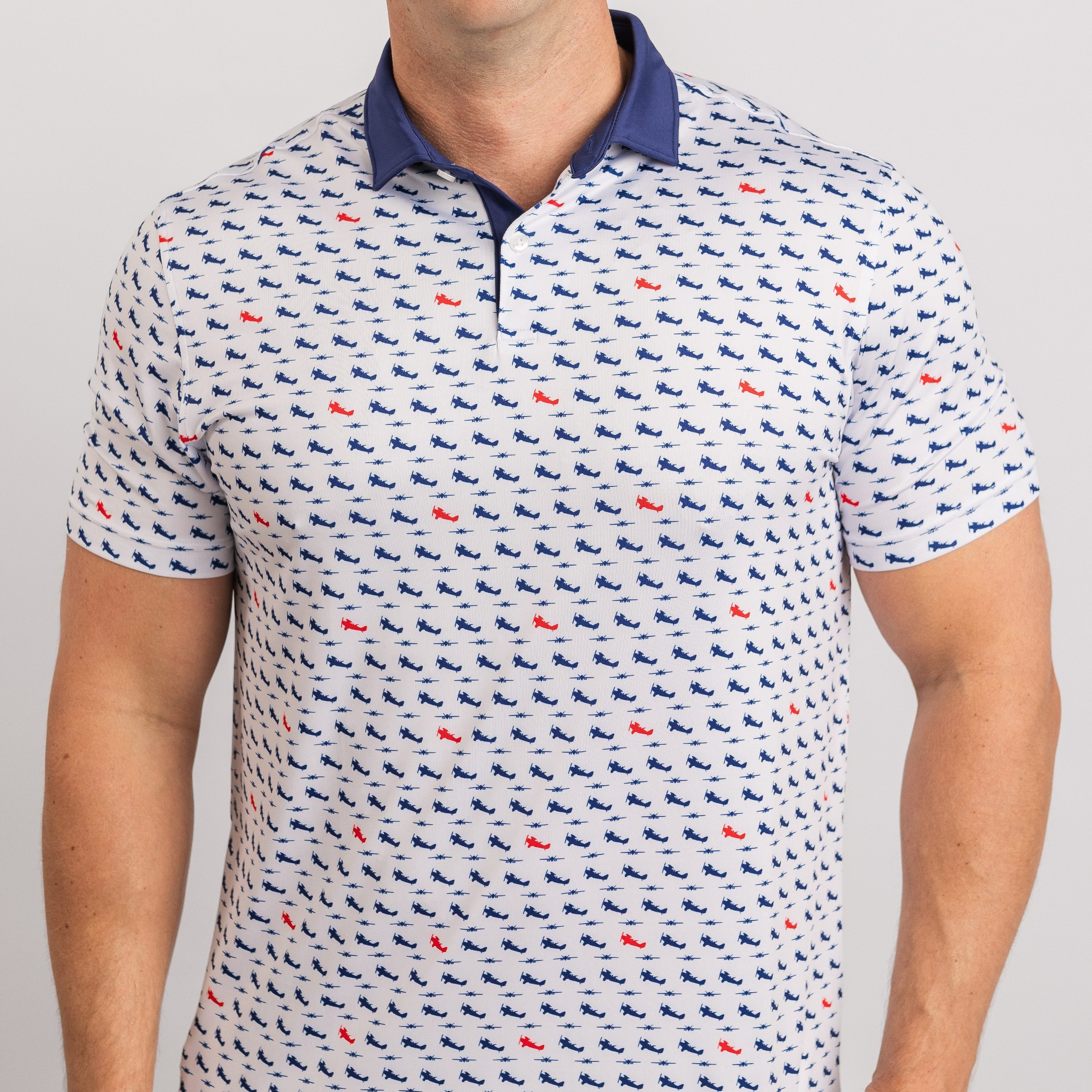 Person wearing a patterned polo shirt with small designs on a plain background