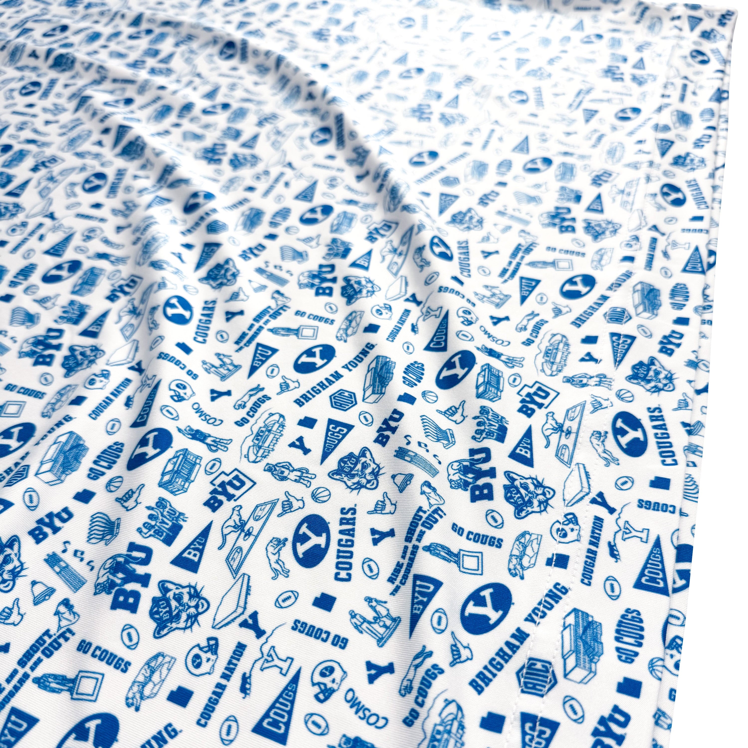 Polo with blue and white pattern featuring various symbols and text on a white background