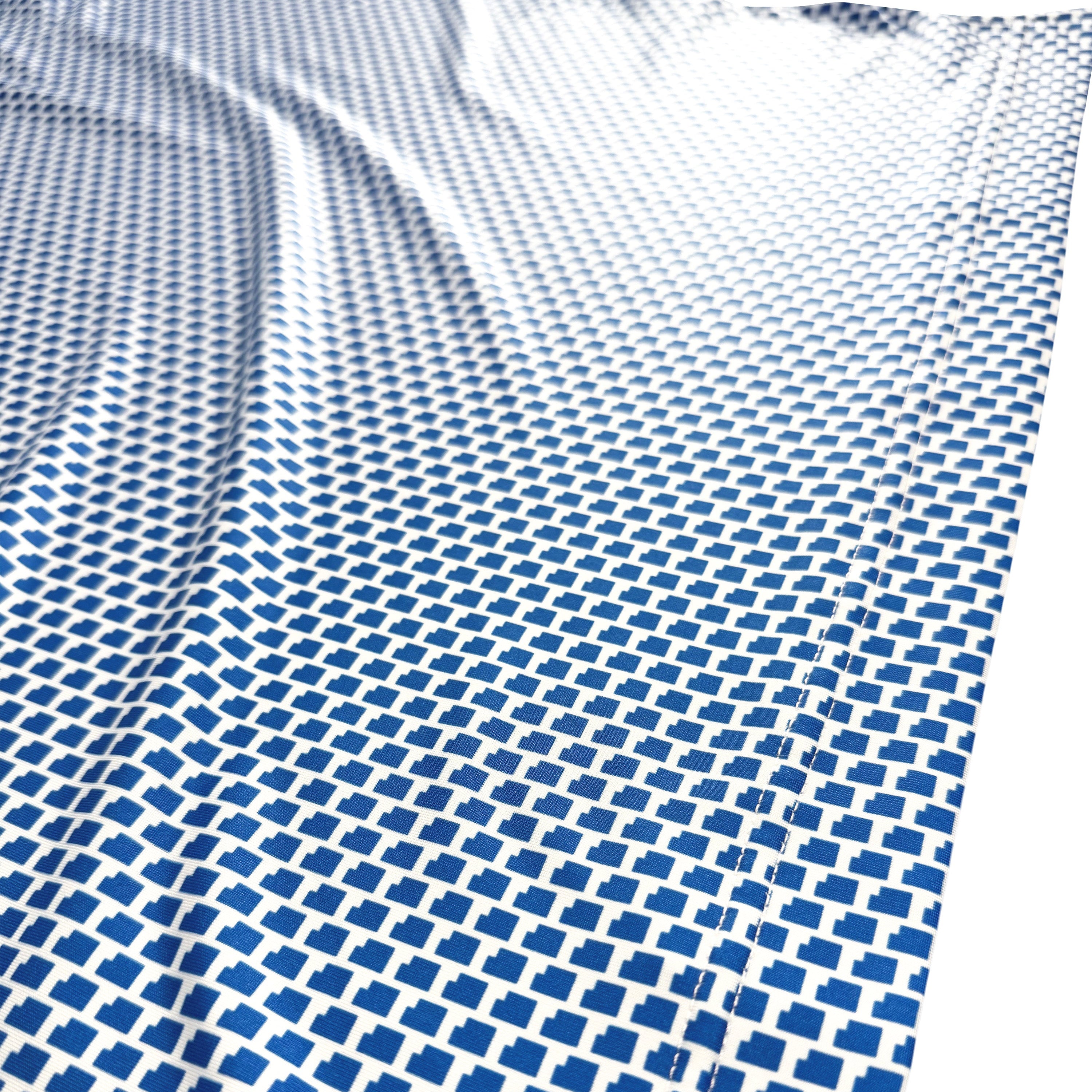A close-up of a white fabric or material printed with a repeating blue geometric pattern, shown with soft folds and a bright white area at the top right.