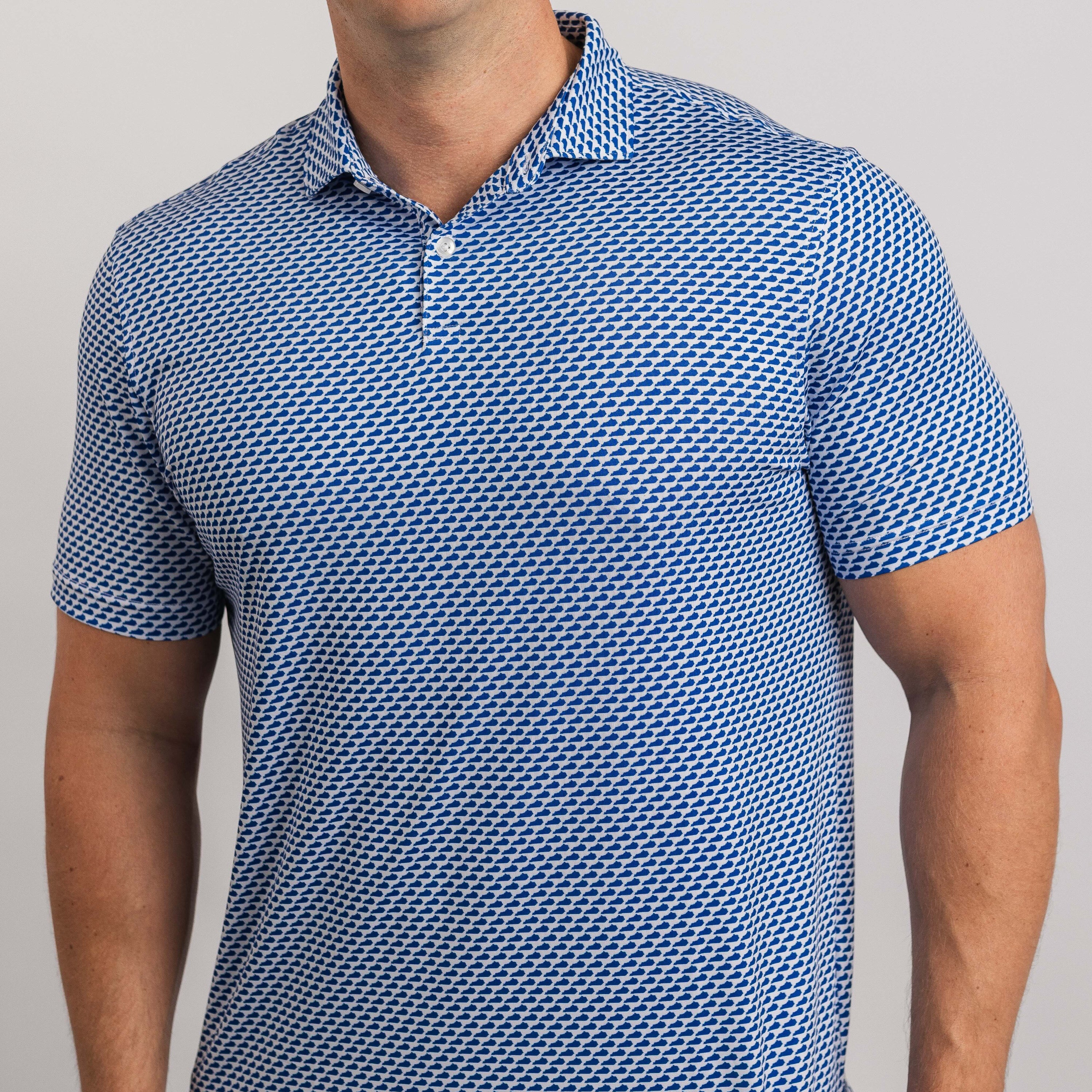 Man wearing a blue patterned polo shirt on a gray background