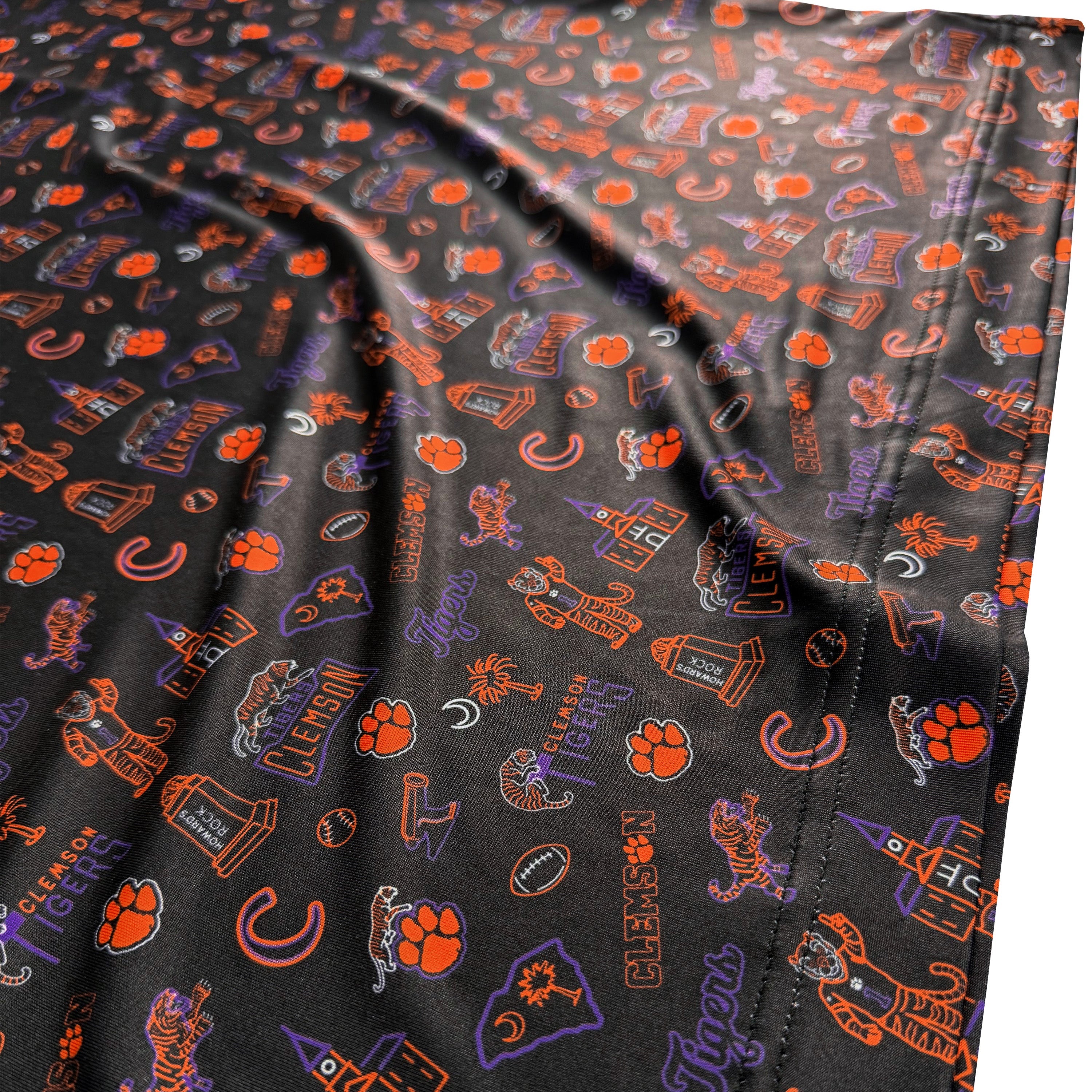 Black fabric with orange and purple patterns featuring logos and text, including 'Clemson' and paw prints.