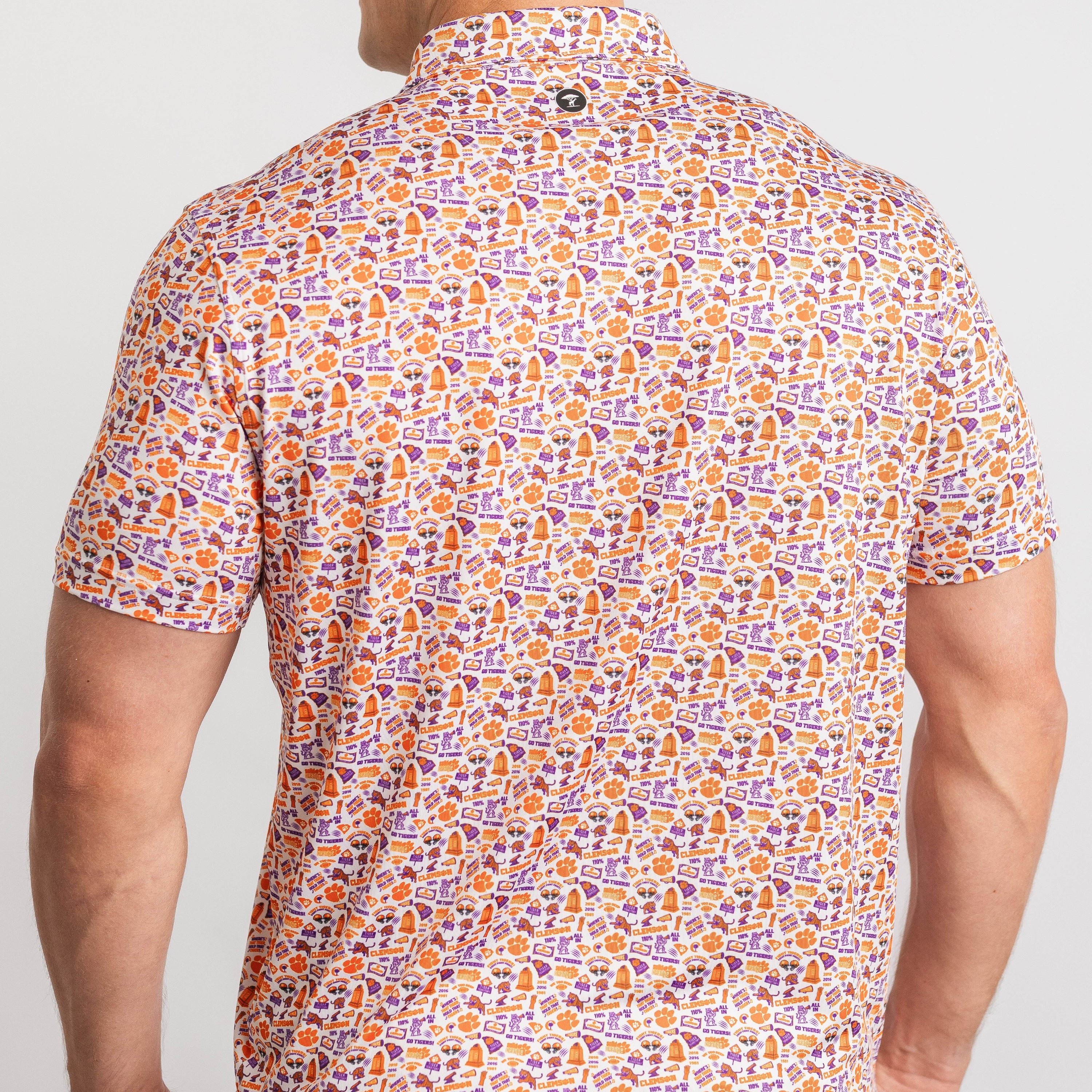 Person wearing a patterned shirt with orange and purple design on a plain background