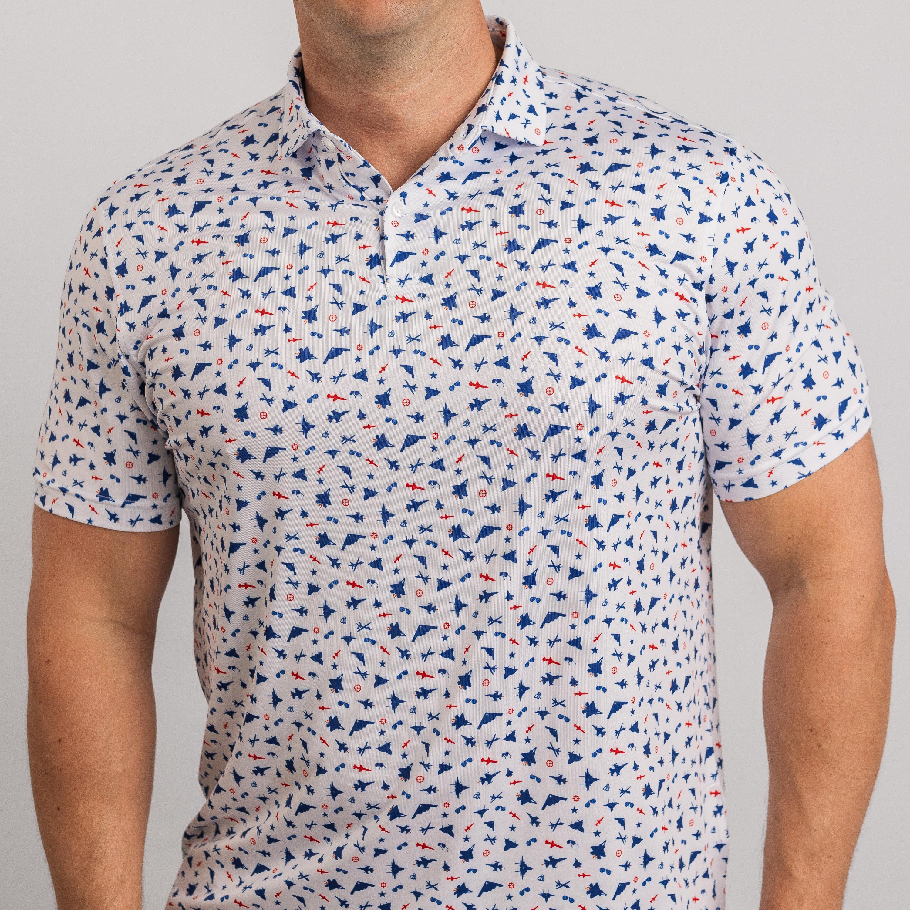 Man wearing a patterned short-sleeve shirt with small blue and red designs on a light gray background
