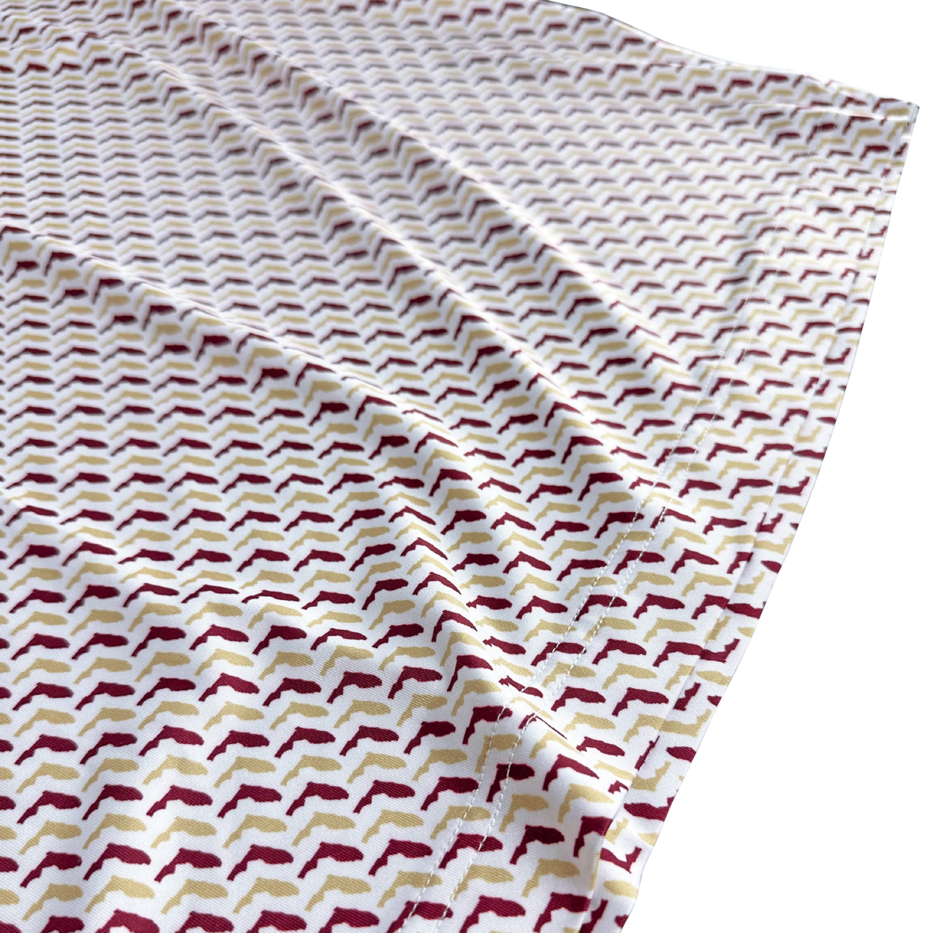 Fabric with a pattern of red and beige shapes on a white background