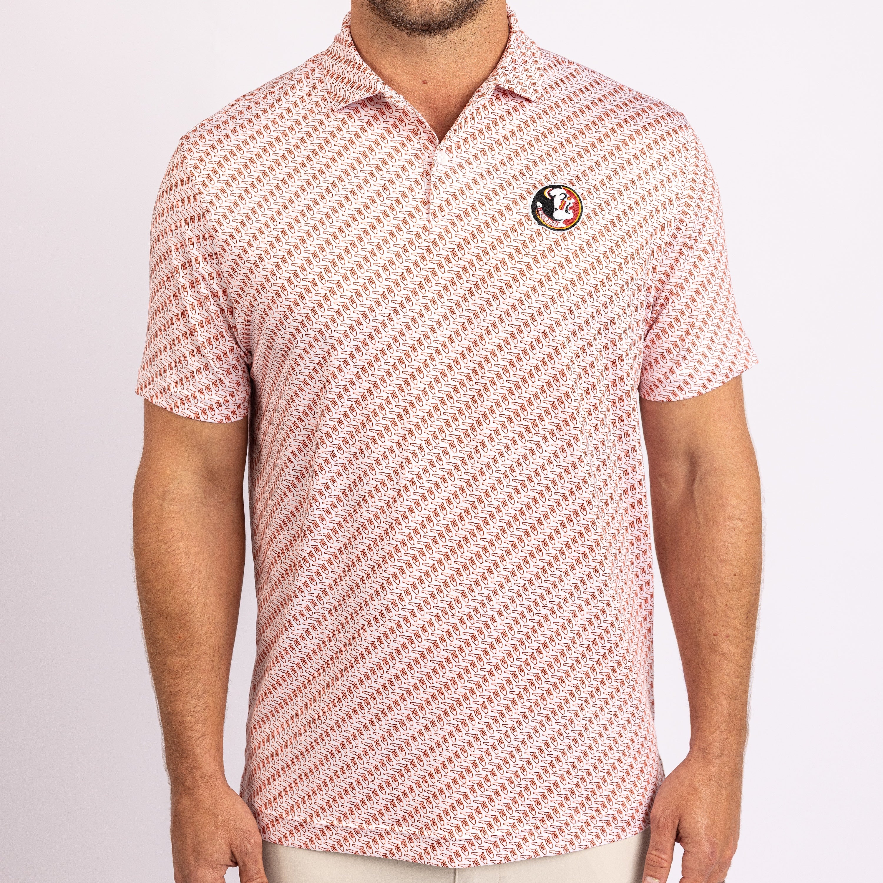 A man wearing a short-sleeve polo shirt with a diagonal red and white pattern, featuring a Florida State Seminoles logo patch on the left chest, photographed against a light gray studio background.