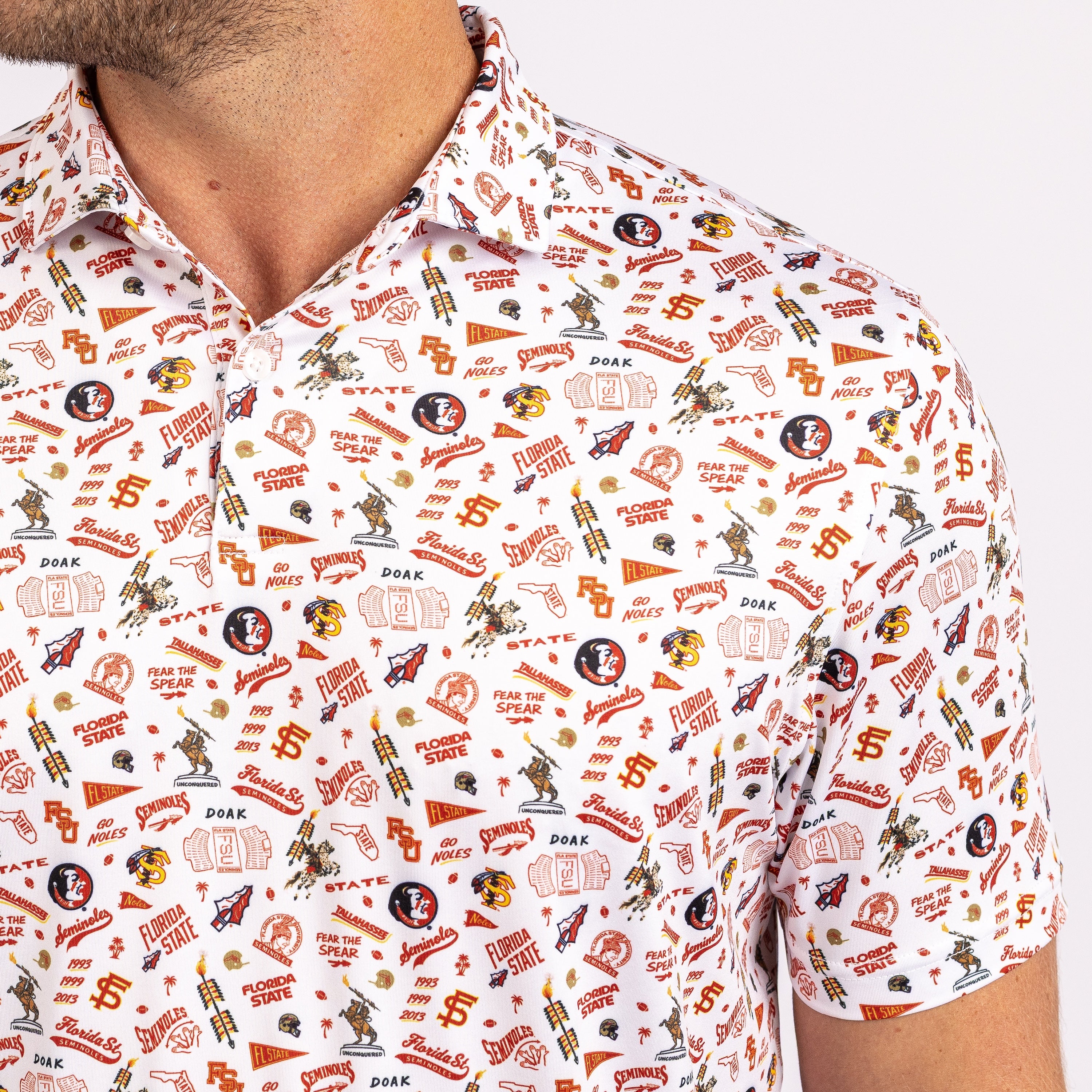 A close-up of a man wearing a short-sleeve button-up shirt with an all-over Florida State Seminoles football-themed print on a white background.