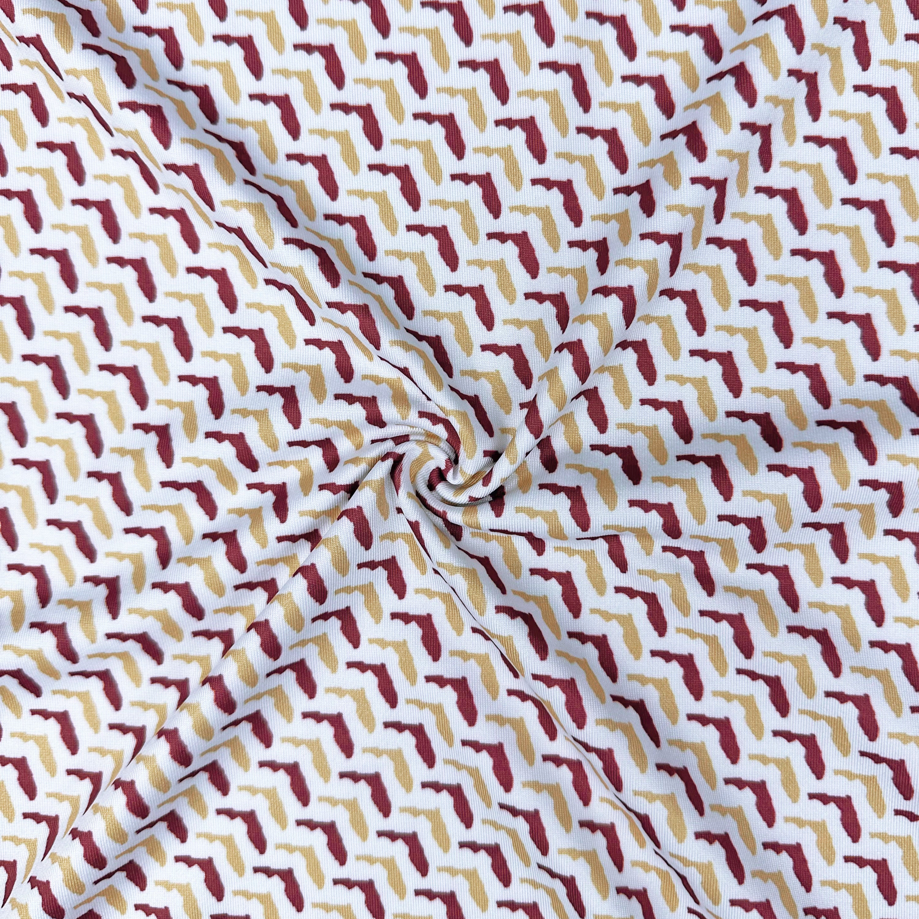 Fabric with a geometric pattern of red, yellow, and white shapes on a white background