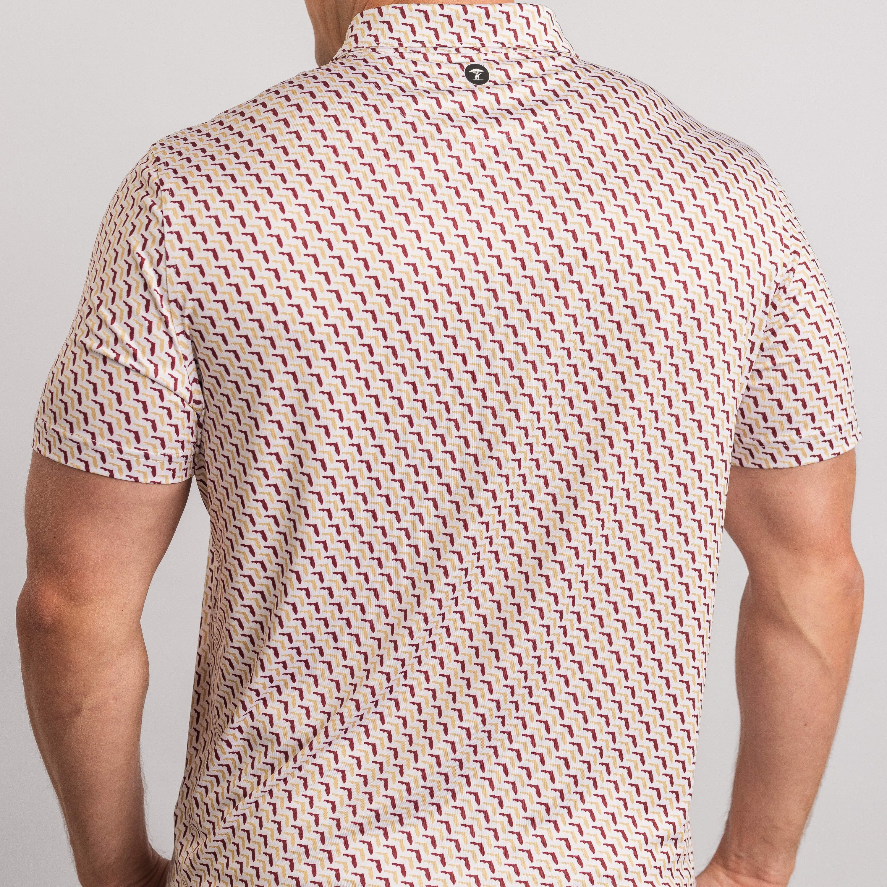 Person wearing a patterned shirt on a plain background