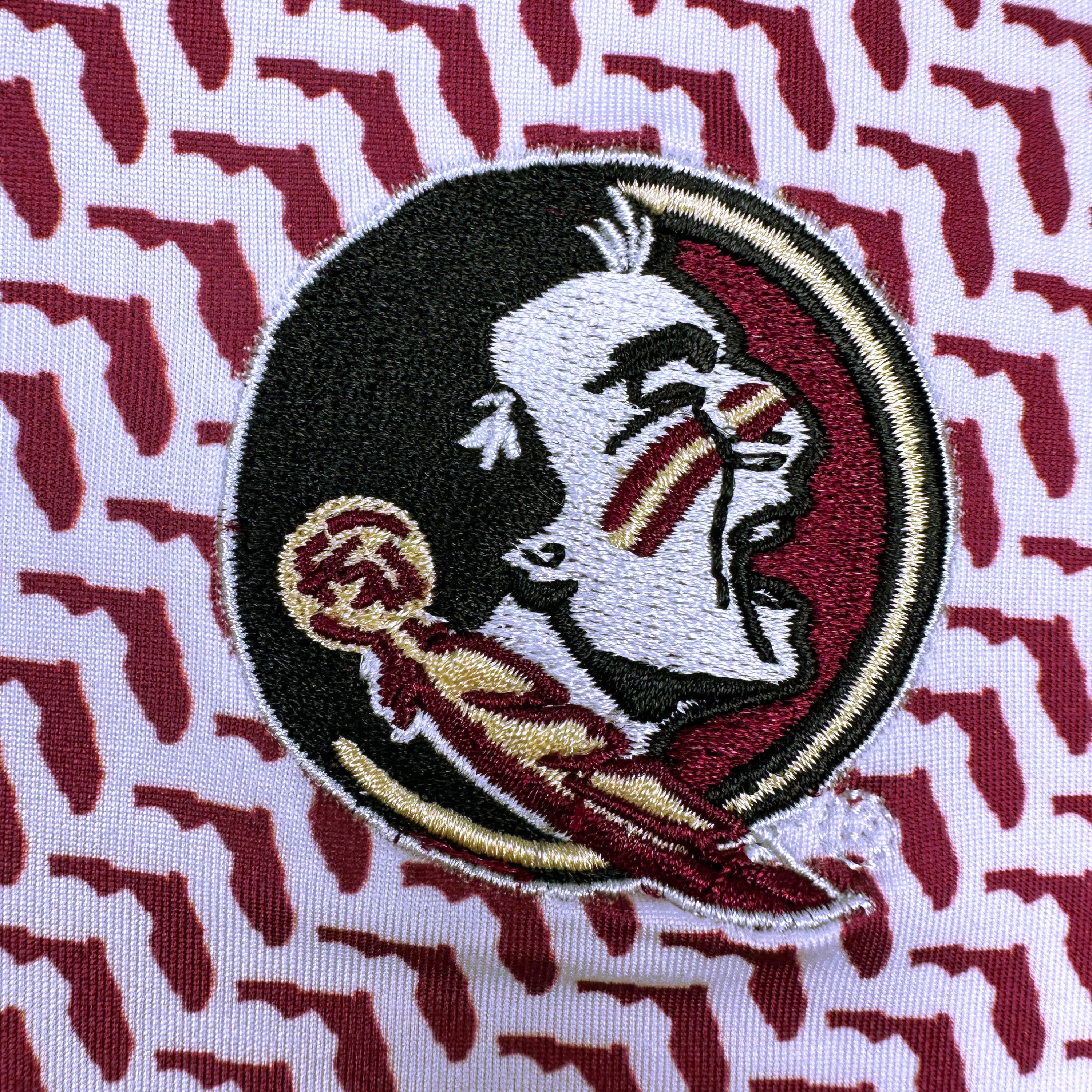 Embroidered logo on a fabric with a red and white pattern