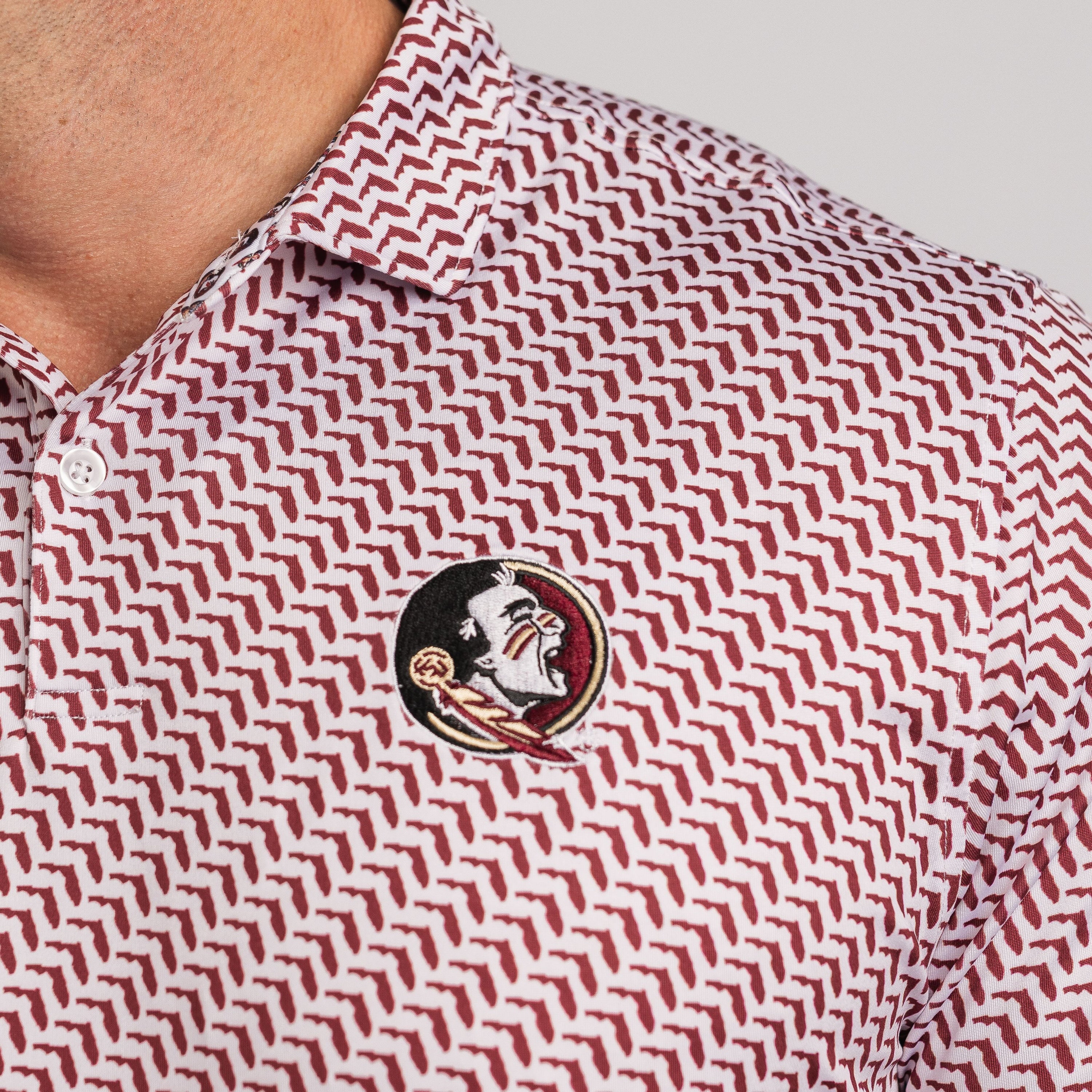 Close-up of a patterned polo shirt with a logo on a plain background