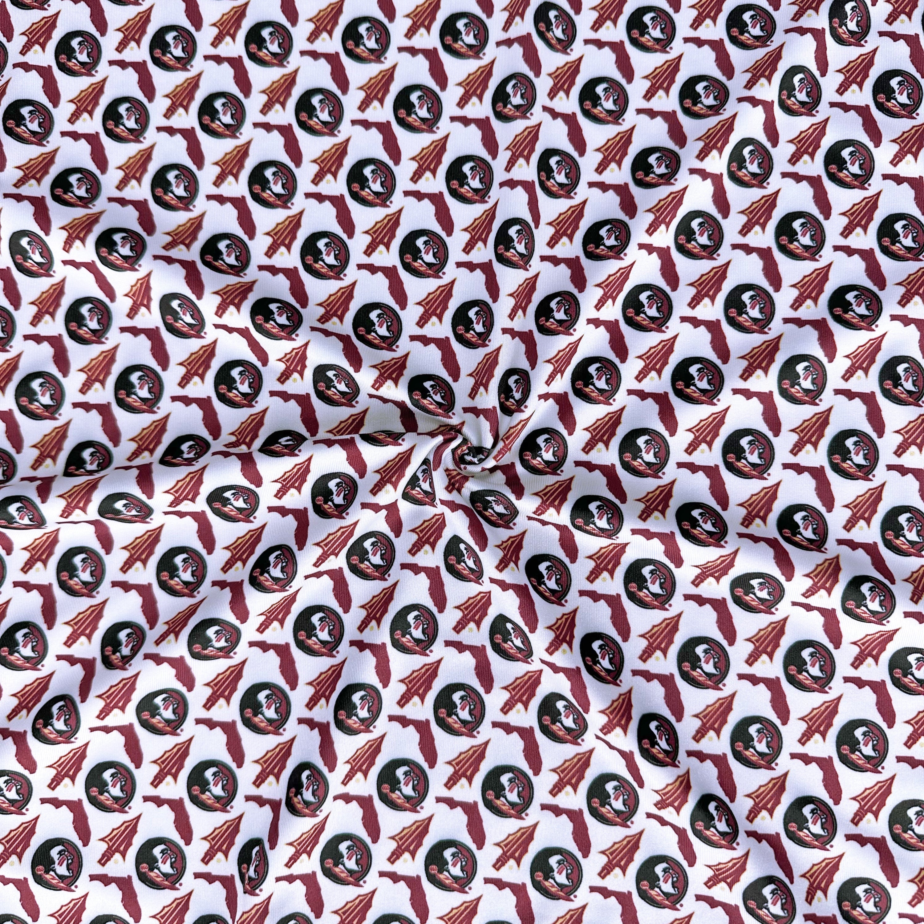 Patterned fabric with circular designs featuring faces and arrows on a white background