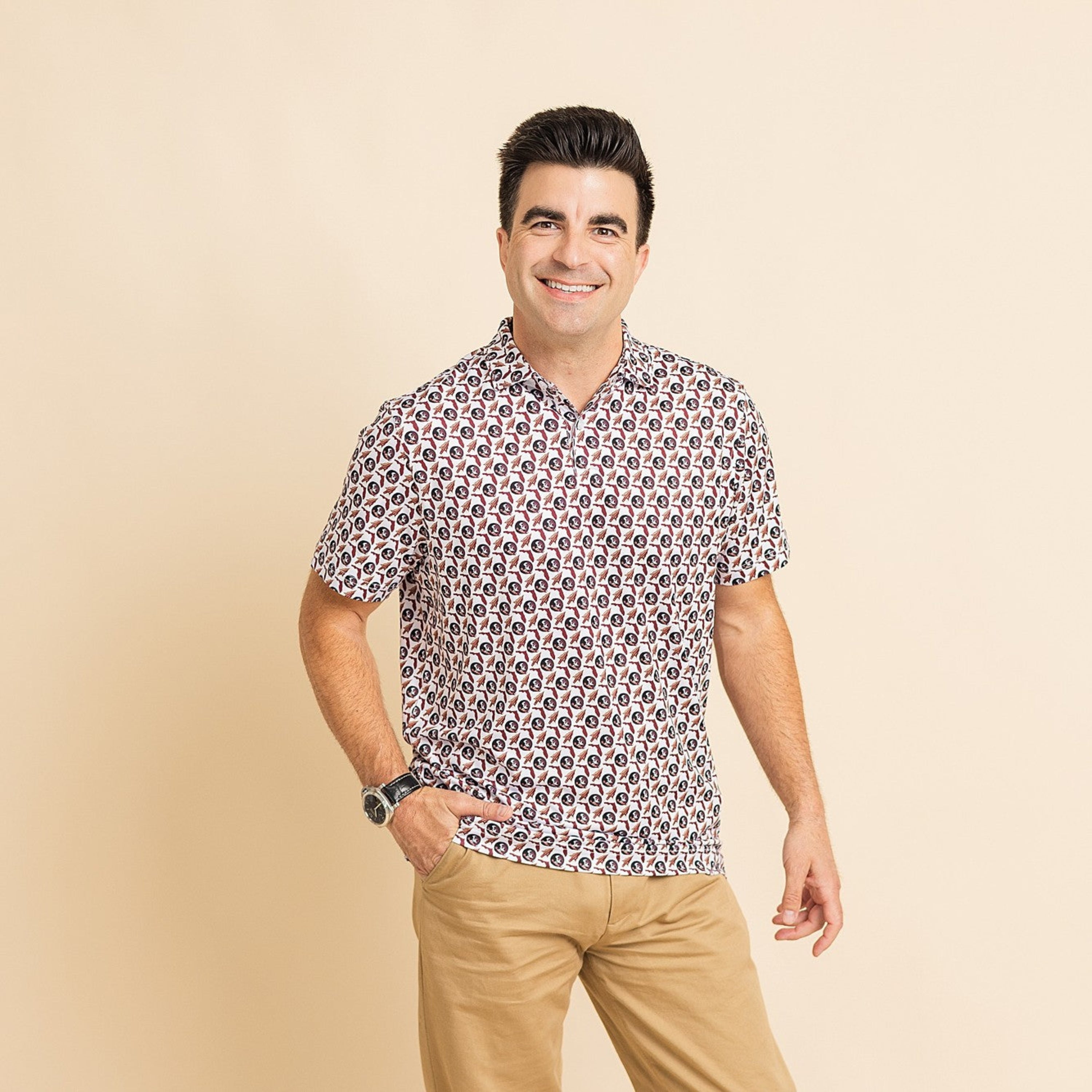 Man wearing a patterned shirt and beige pants on a beige background
