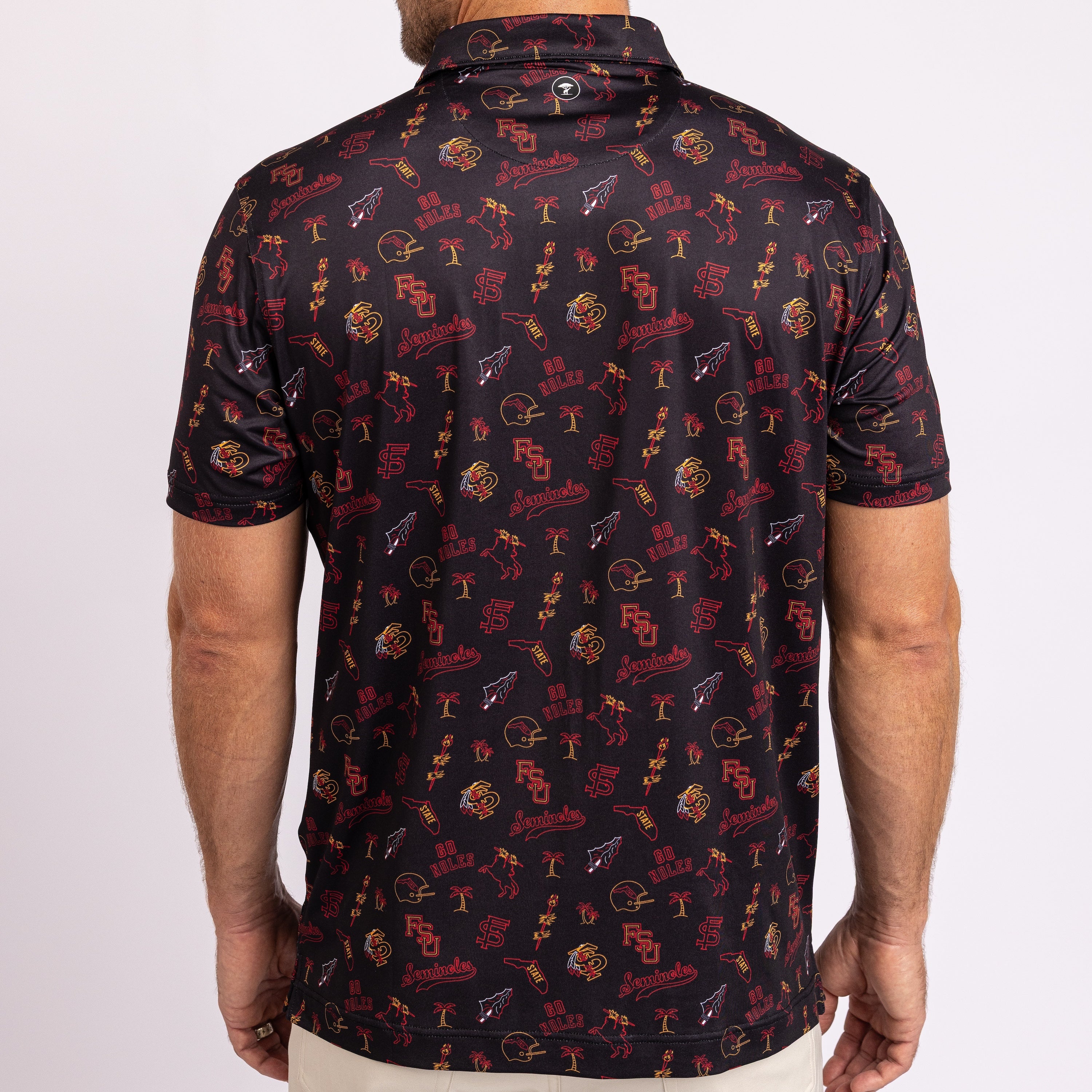A man wearing a short-sleeve polo shirt from the back, featuring an all-over repeating pattern of the Florida State Seminoles logo in red, gold, and white on a black background.