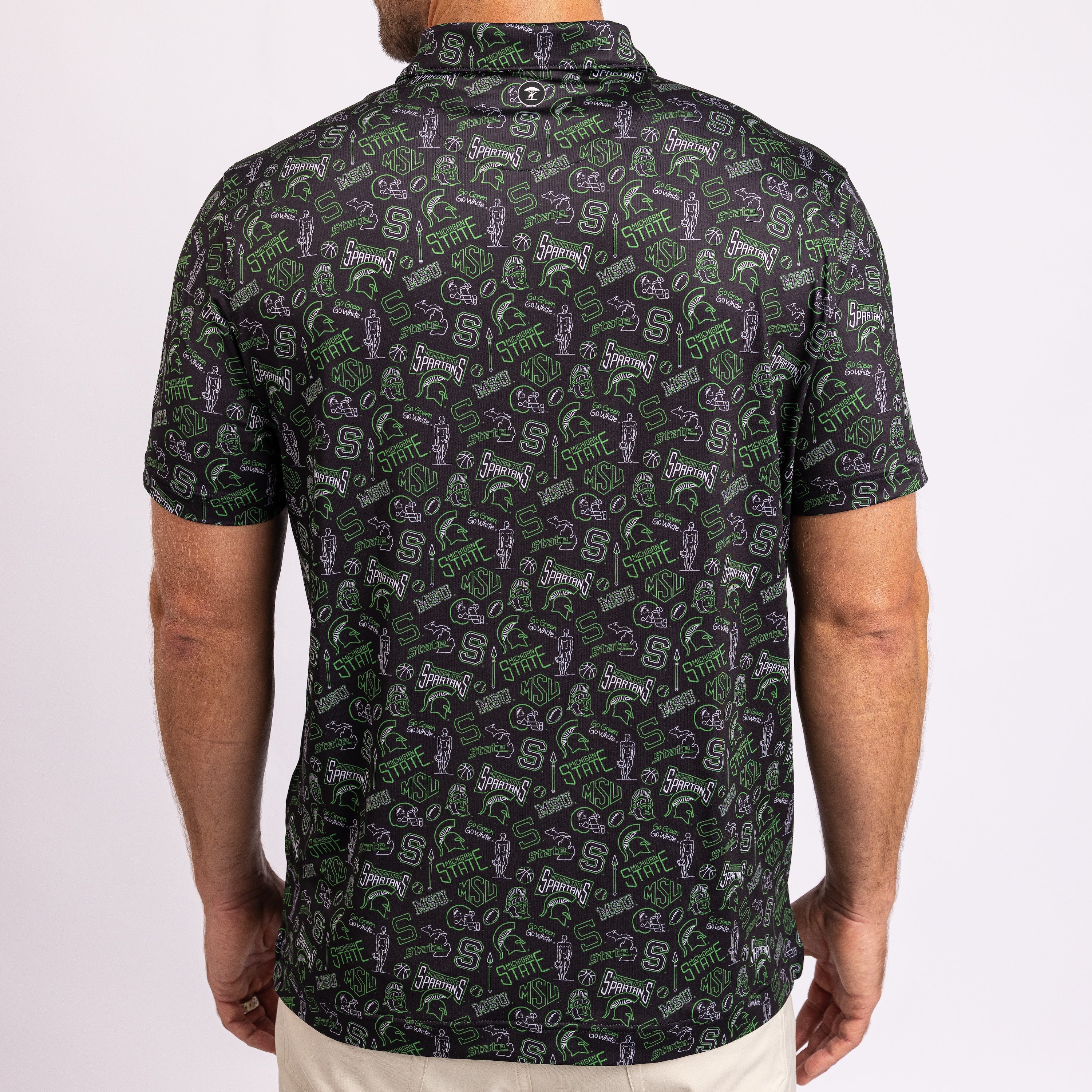A man viewed from the back wearing a short-sleeve button-up shirt with an all-over green, purple, and white