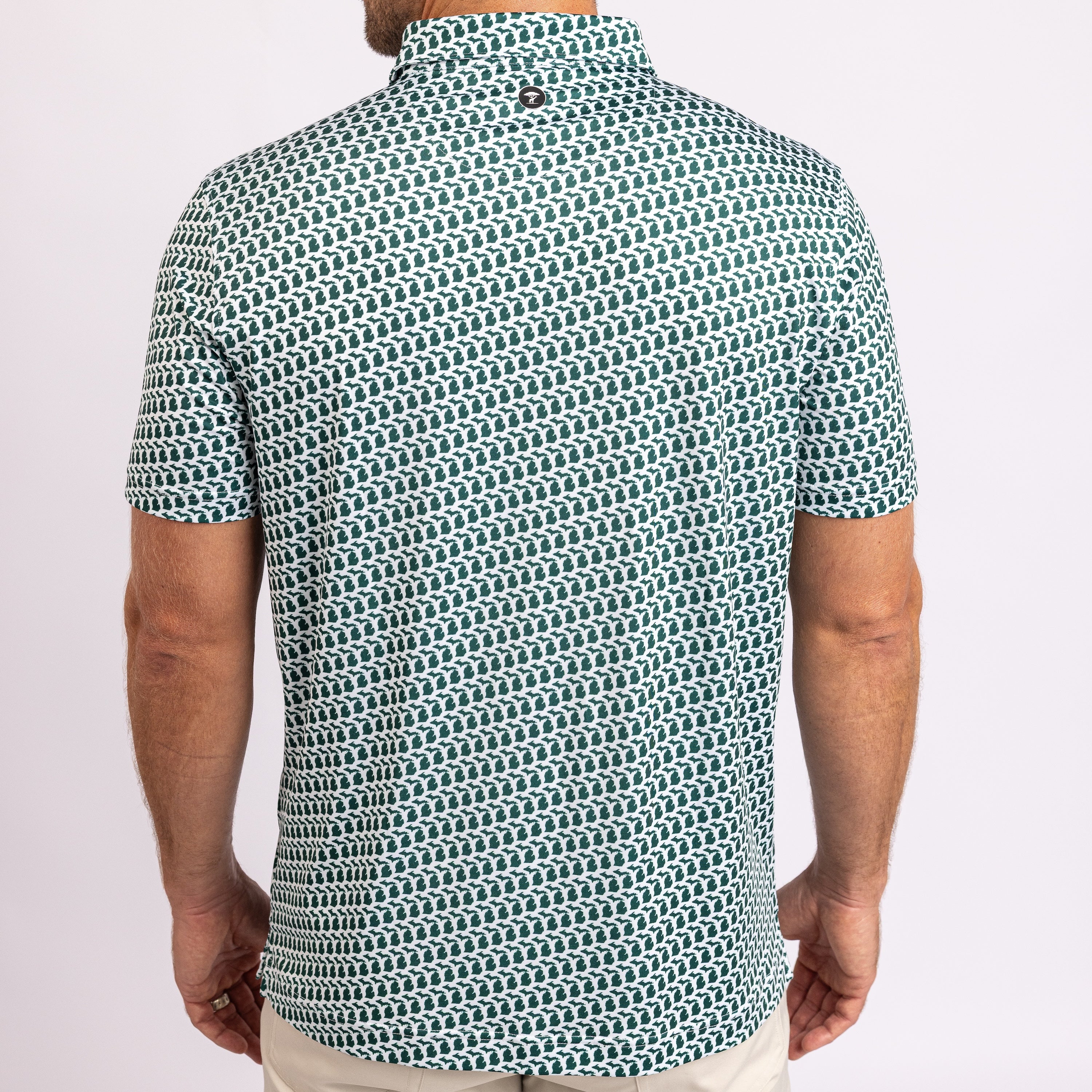 A man viewed from the back wearing a short-sleeve collared shirt with a repeating geometric chain-link pattern in teal and white.