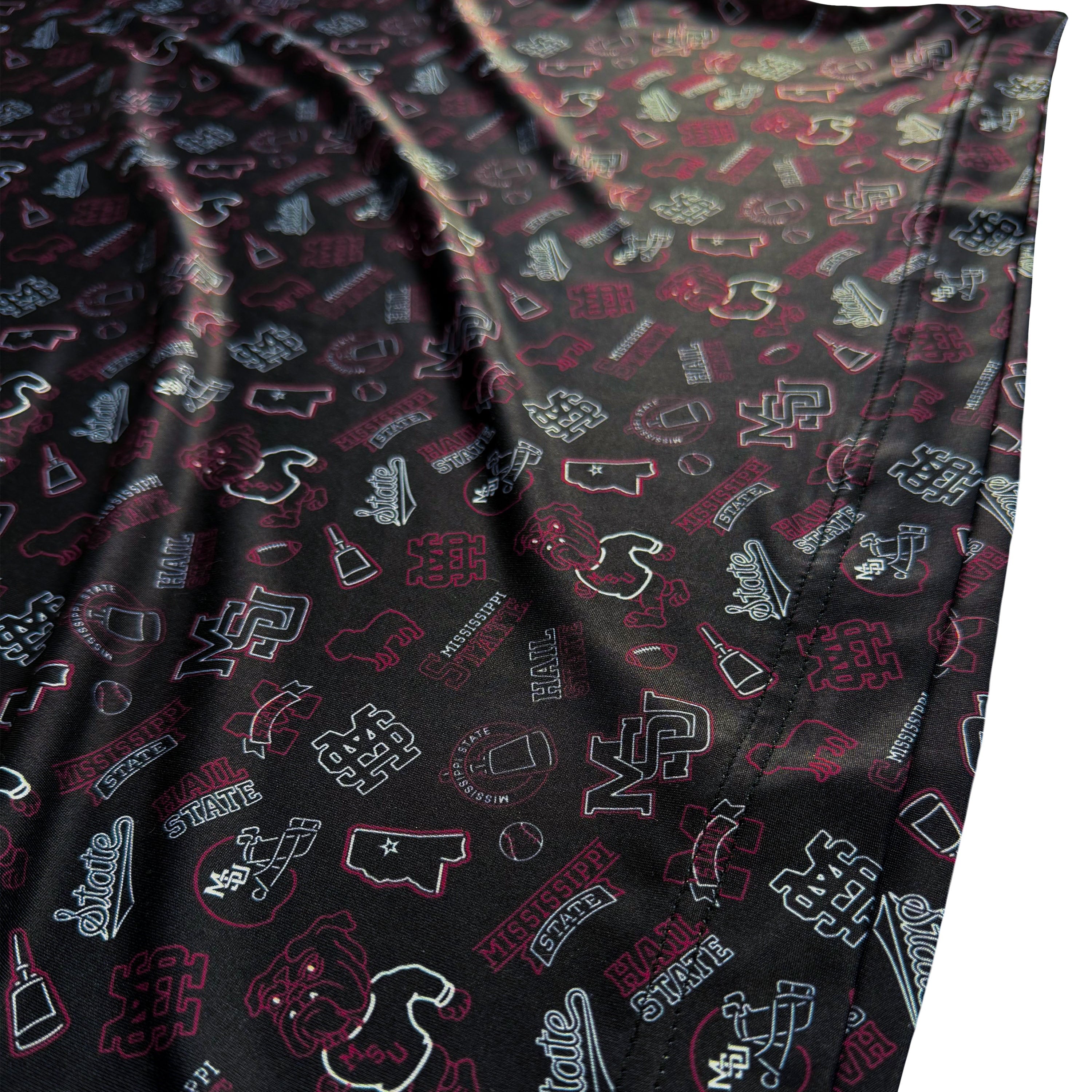 Folded fabric with various patterns and logos on a black background