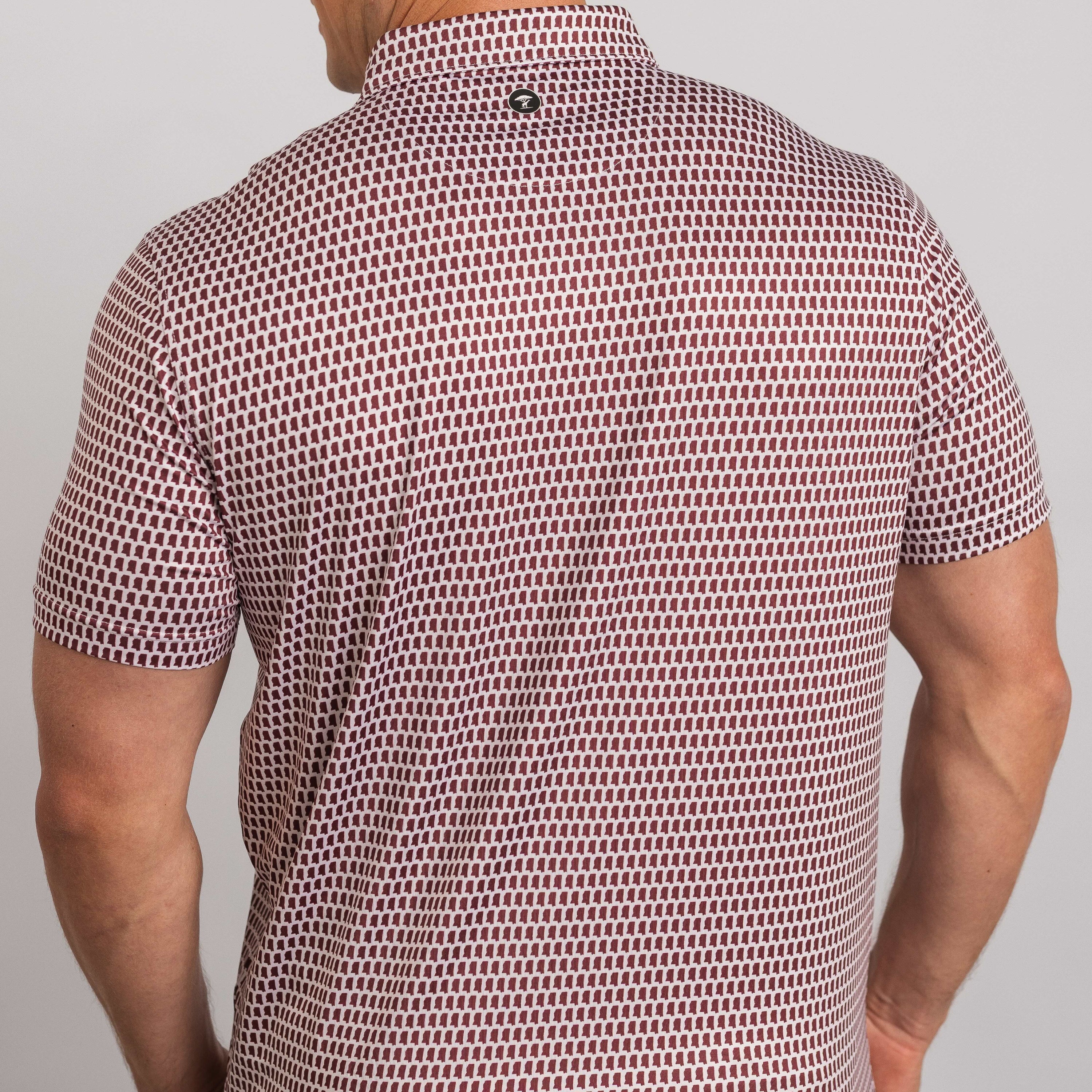 Man wearing a patterned short-sleeve shirt on a plain background