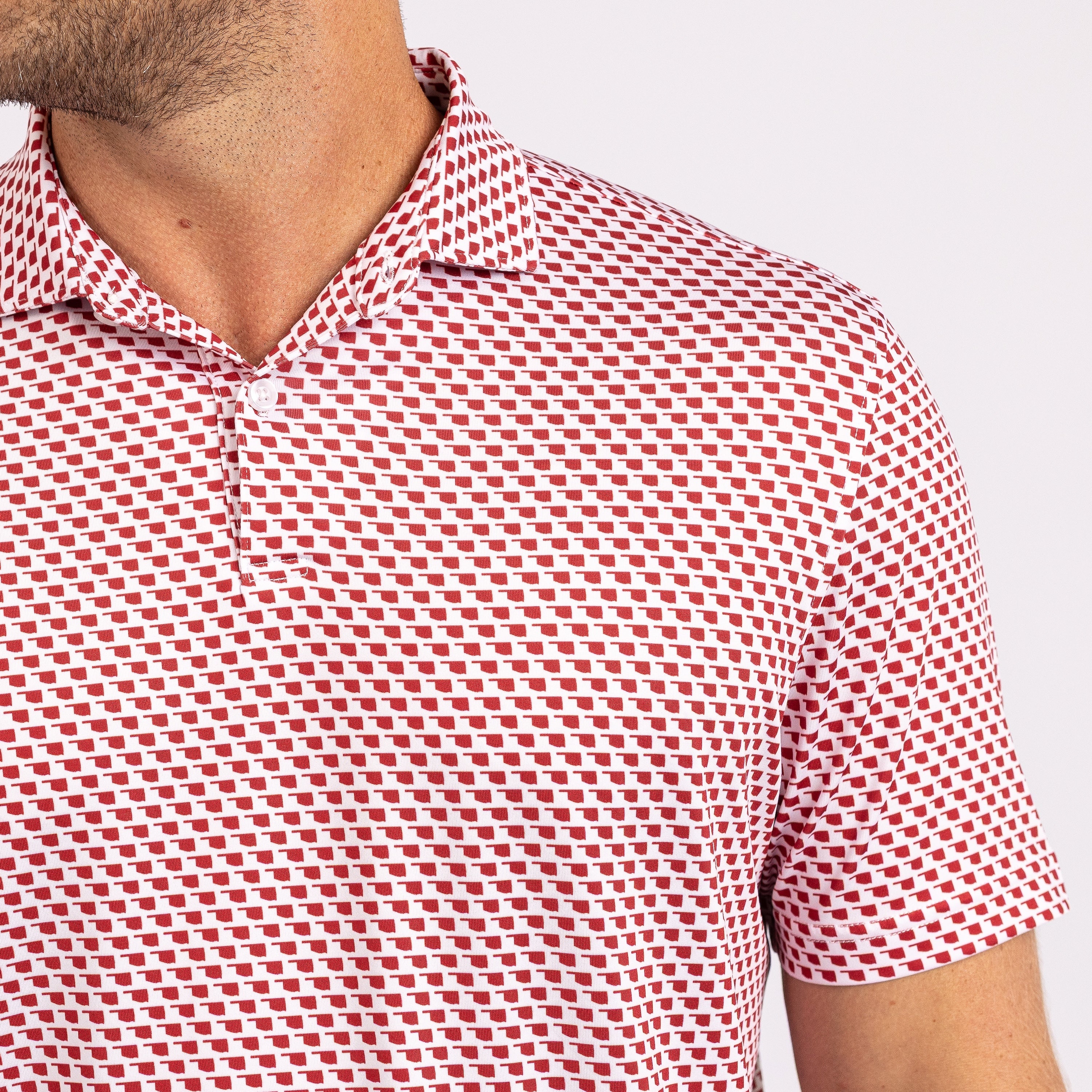 A red and white geometric patterned men's polo shirt with a collar.