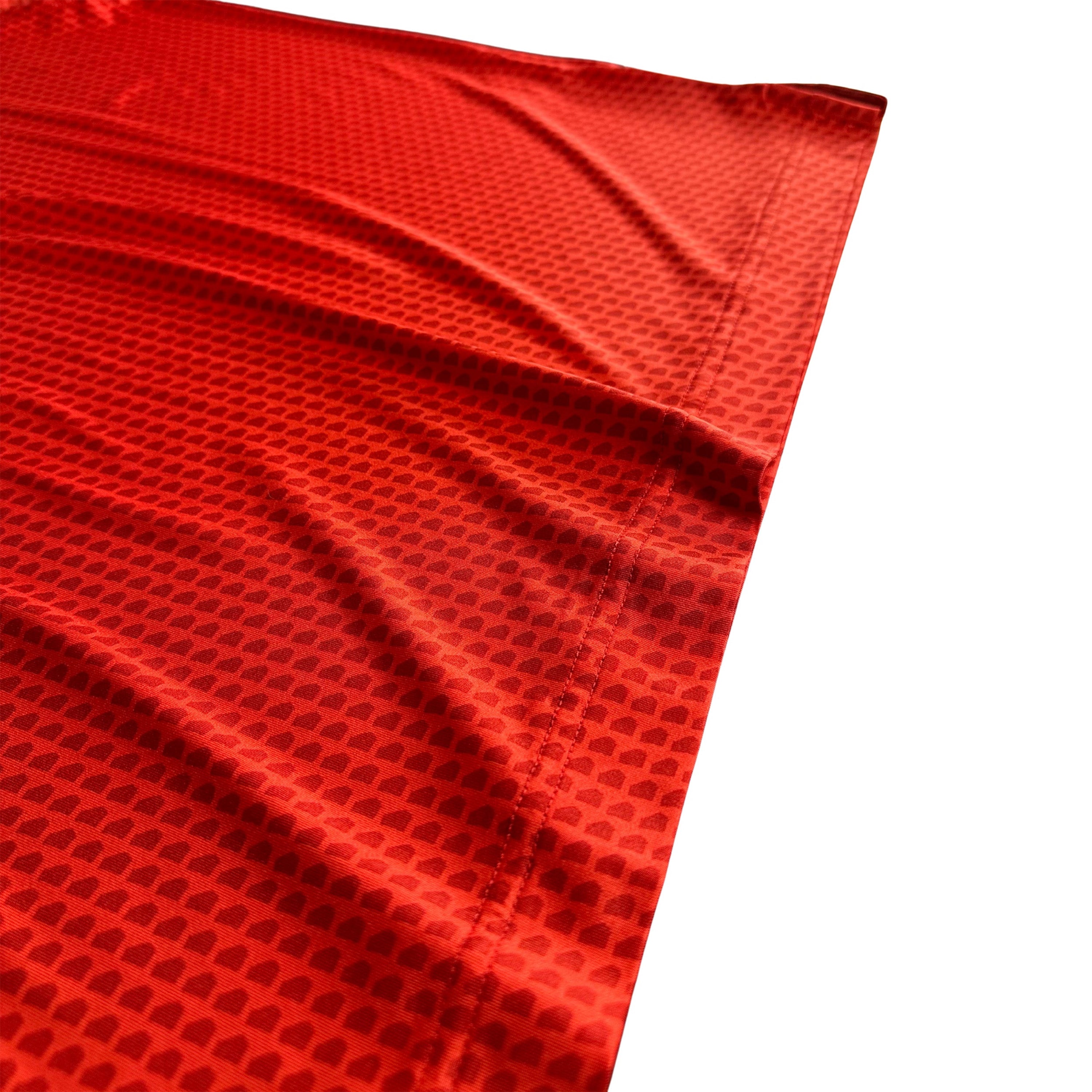 Close-up of red fabric with a textured pattern on a white background