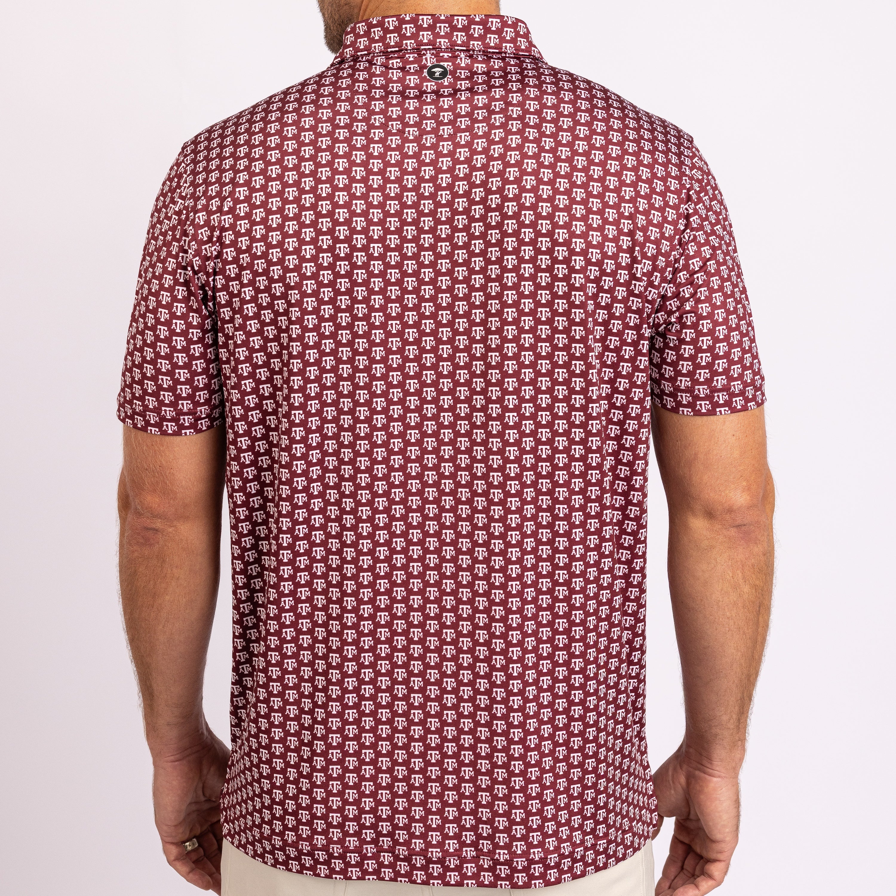 A man viewed from the back wearing a short-sleeve collared shirt with an all-over repeating geometric pattern in burgundy and off-white.