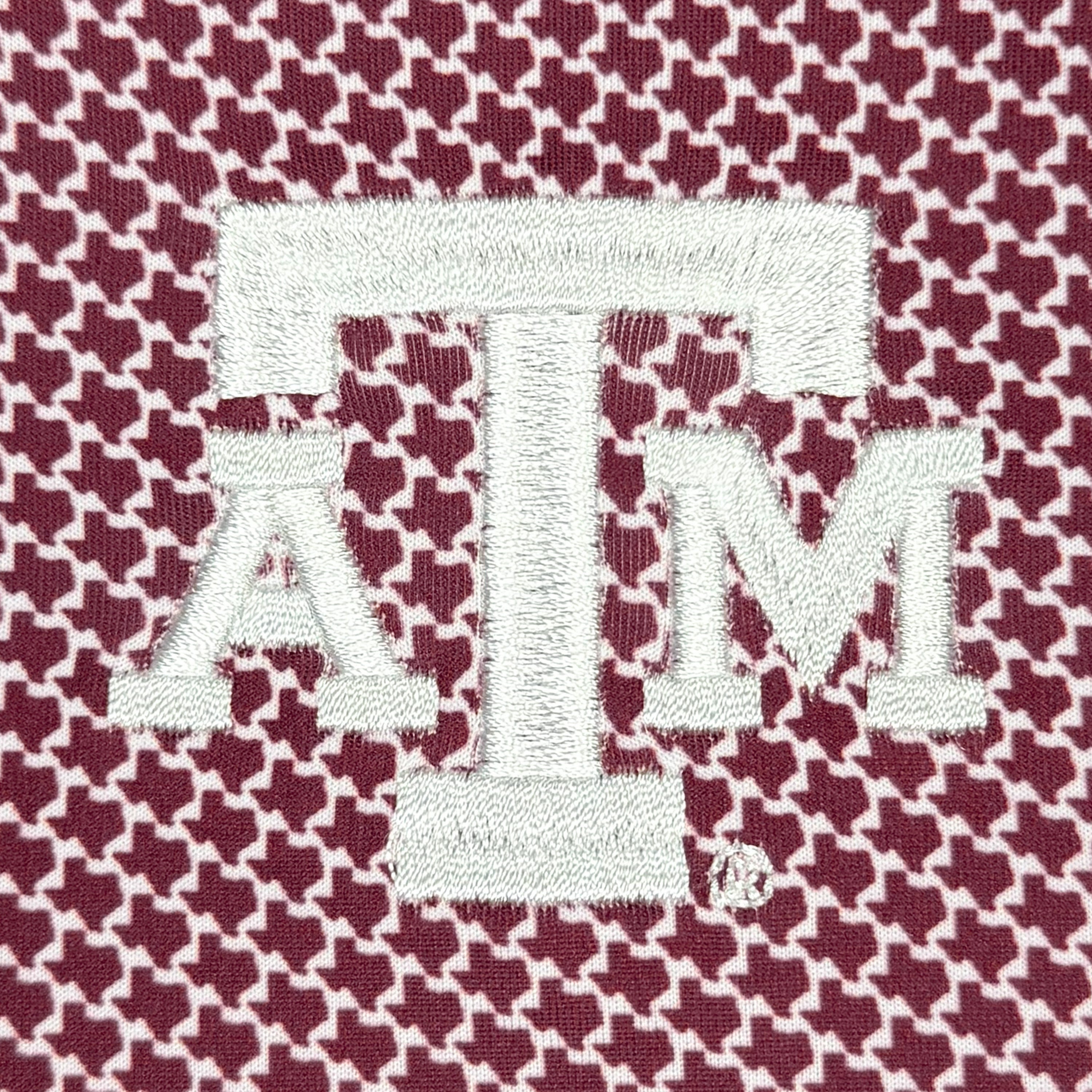 Embroidered 'ATM' logo on a houndstooth patterned fabric