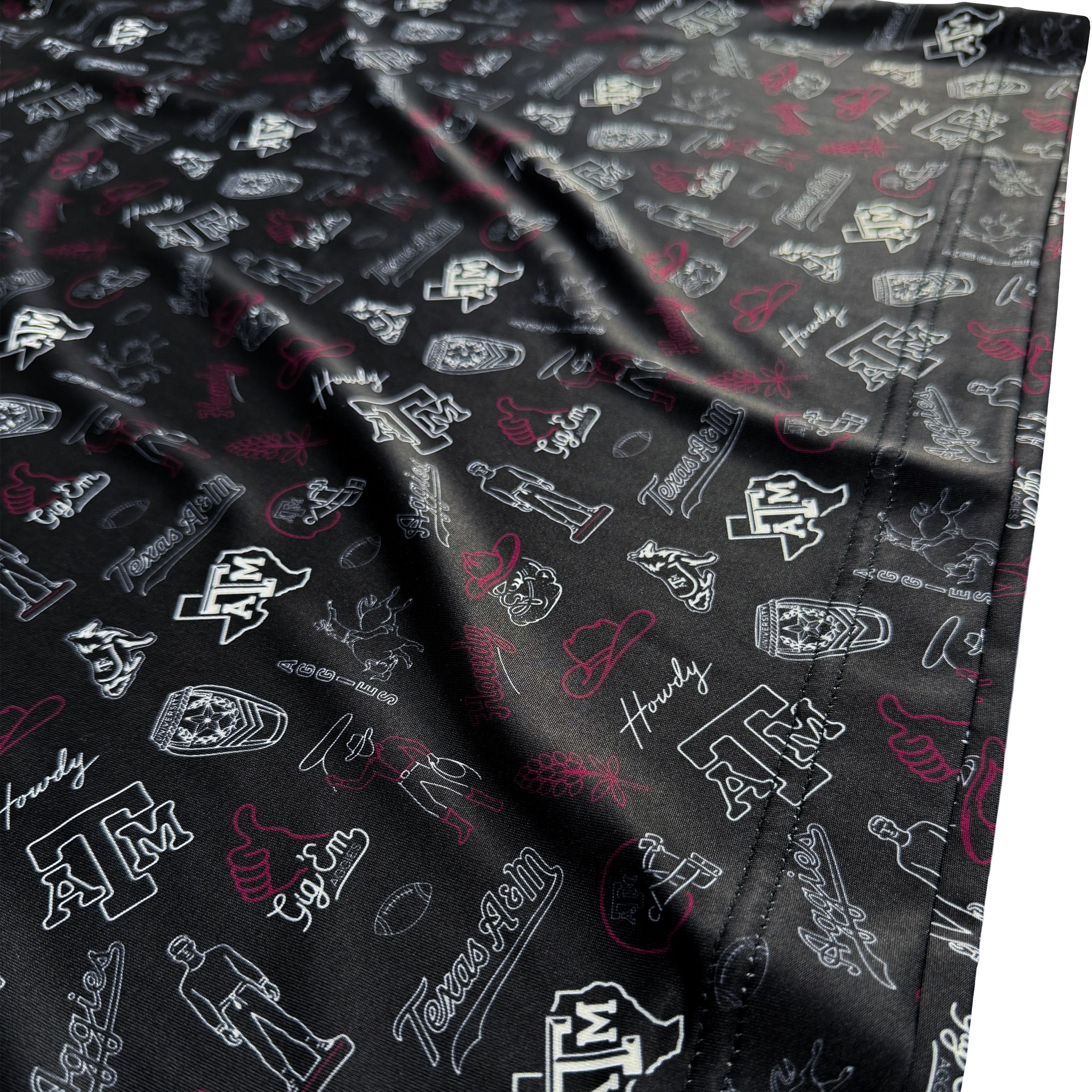 Folded fabric with a pattern of logos and designs on a black background