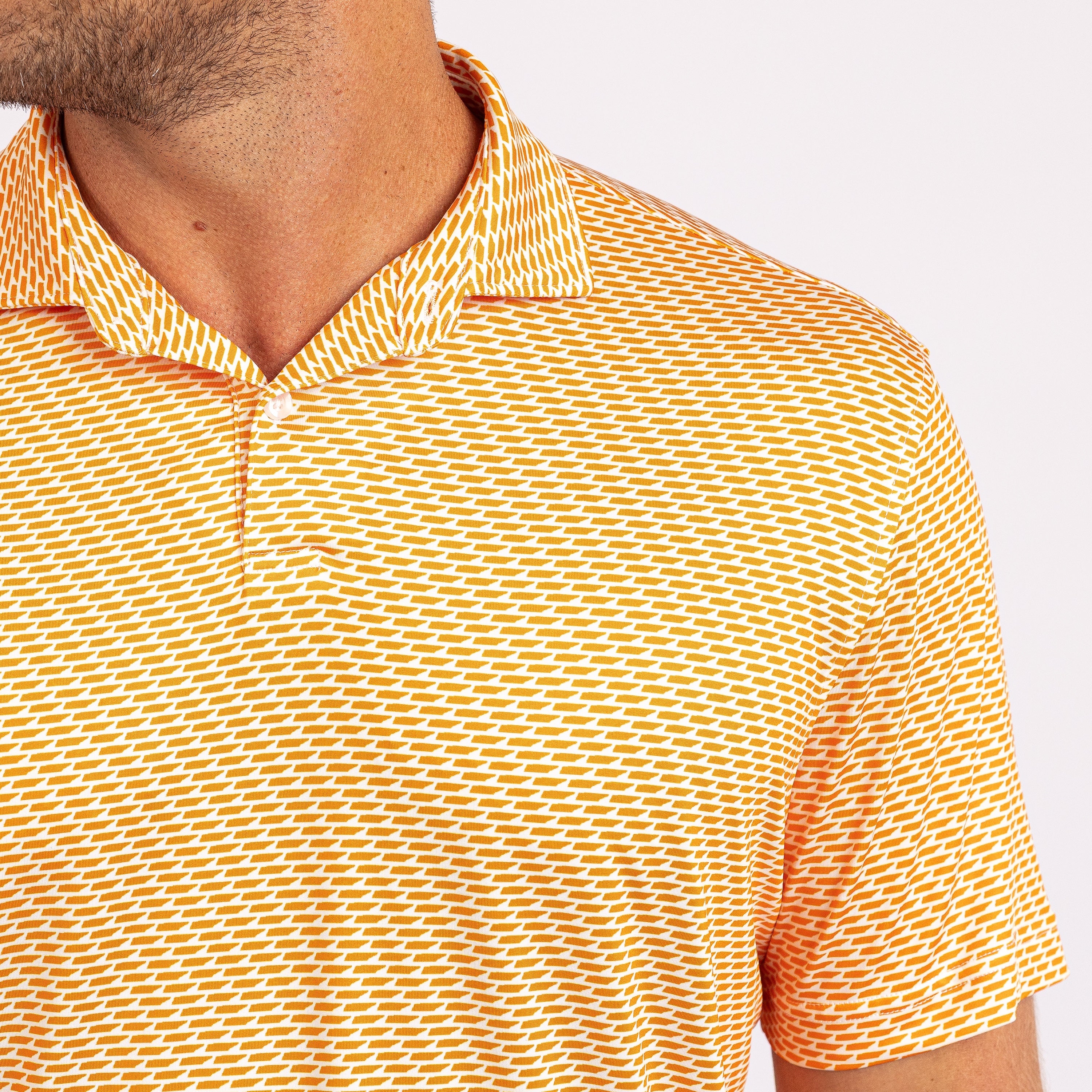 Orange and white patterned polo shirt with a brand logo on a white background