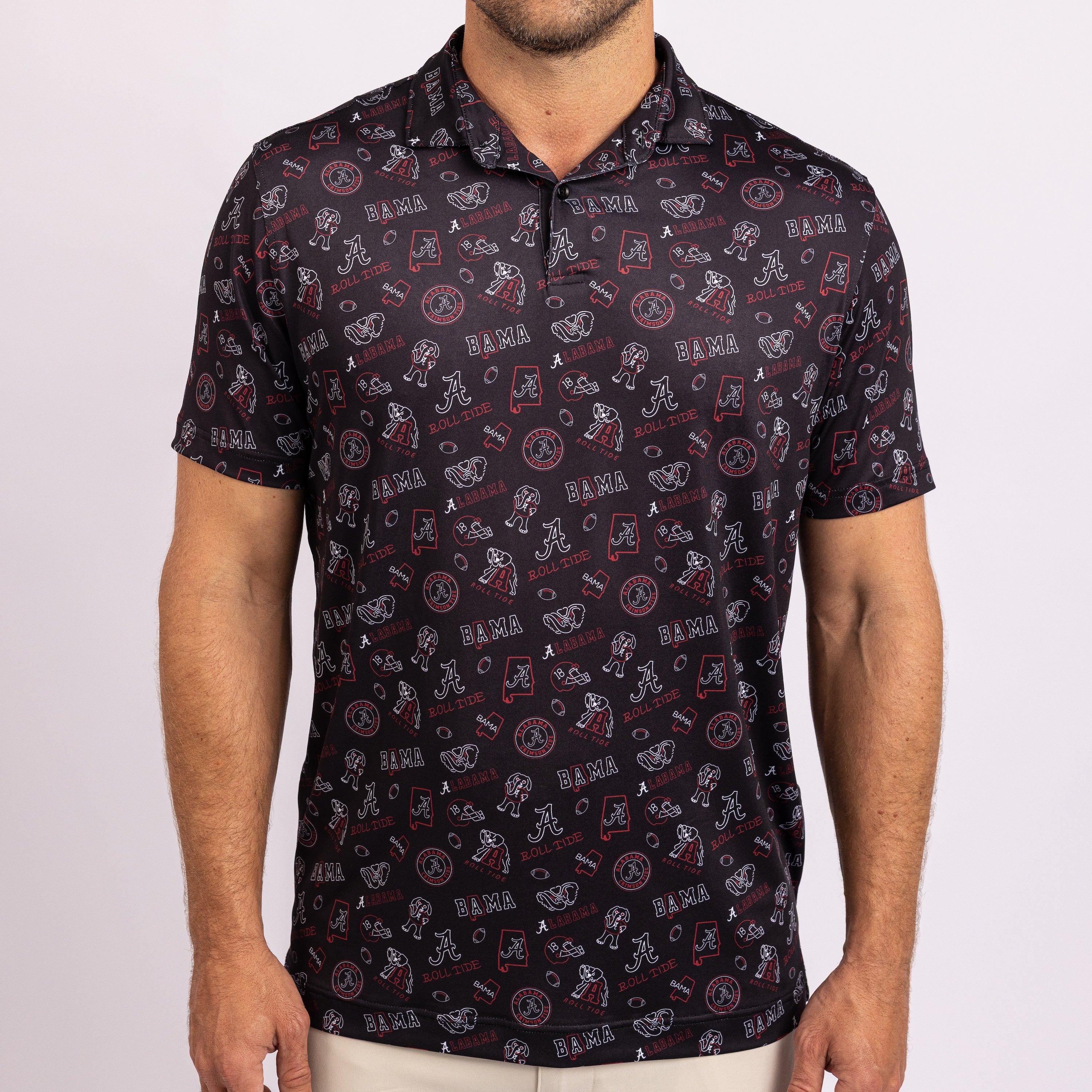 A man wearing a short-sleeve polo shirt with an all-over Alabama Crimson Tide football graphic print on a dark navy background.