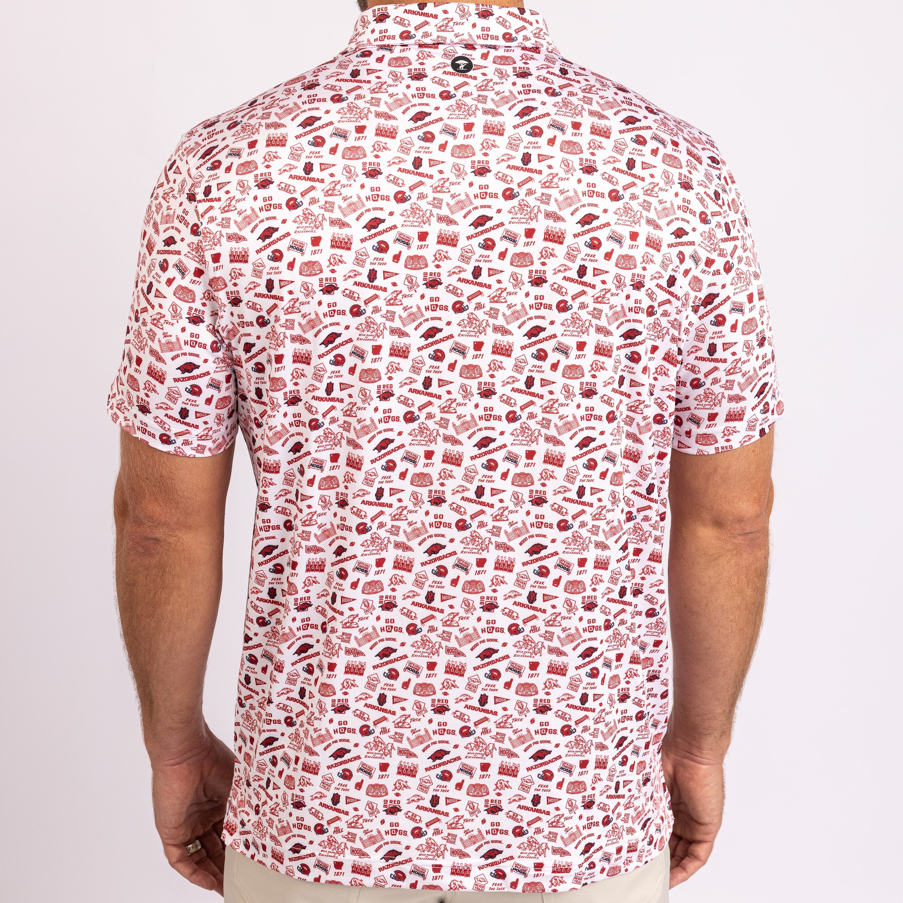 A man wearing a short-sleeve button-up shirt with a dense red and pink food-themed pattern on a white background, shown from the back.