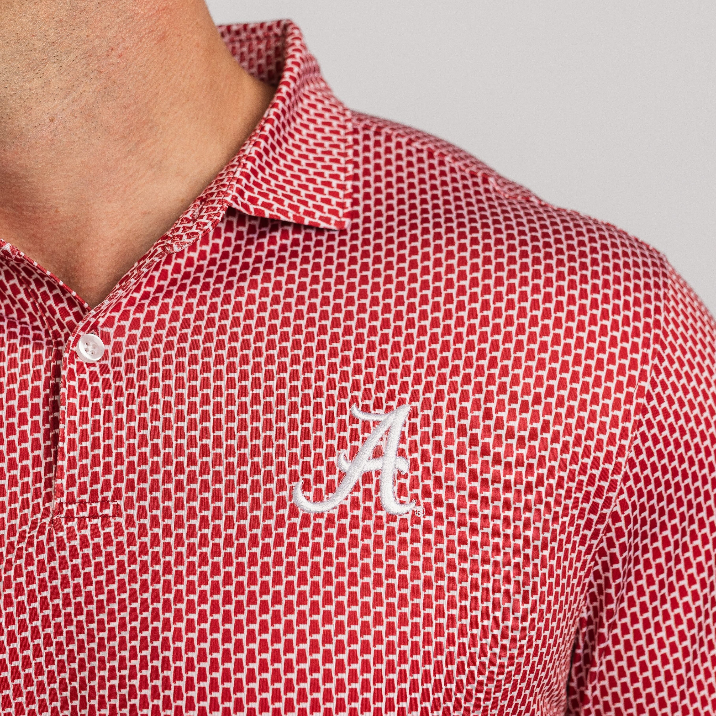 Red patterned polo shirt with a white logo on a gray background