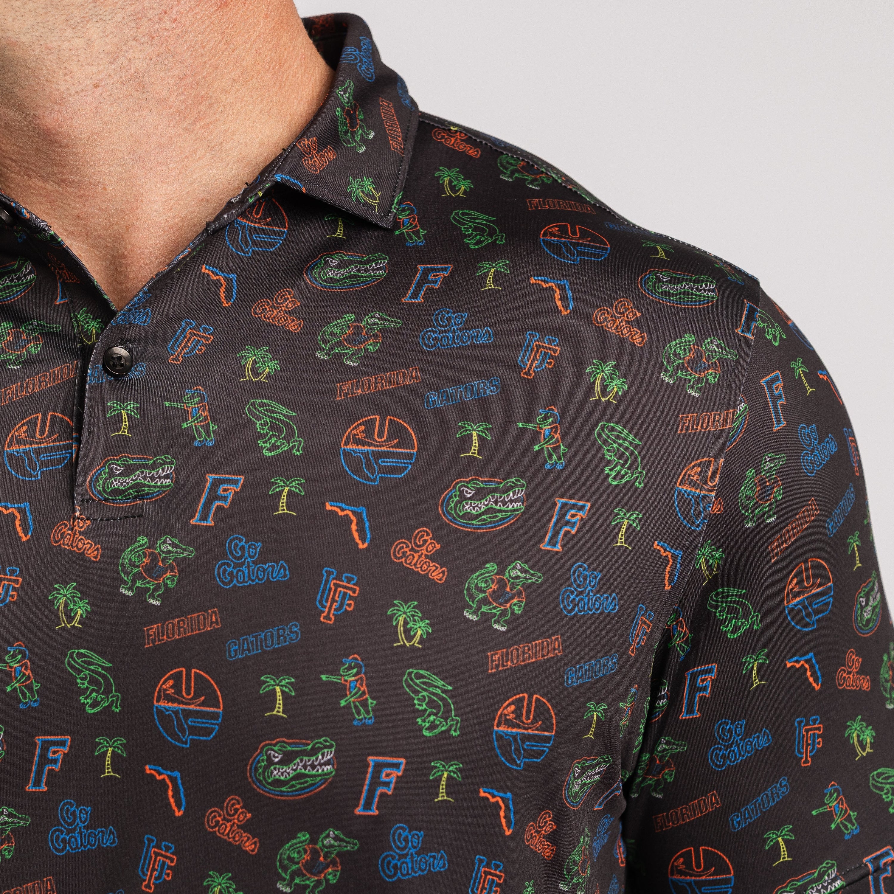 Black polo shirt with colorful patterns and logos on a white background
