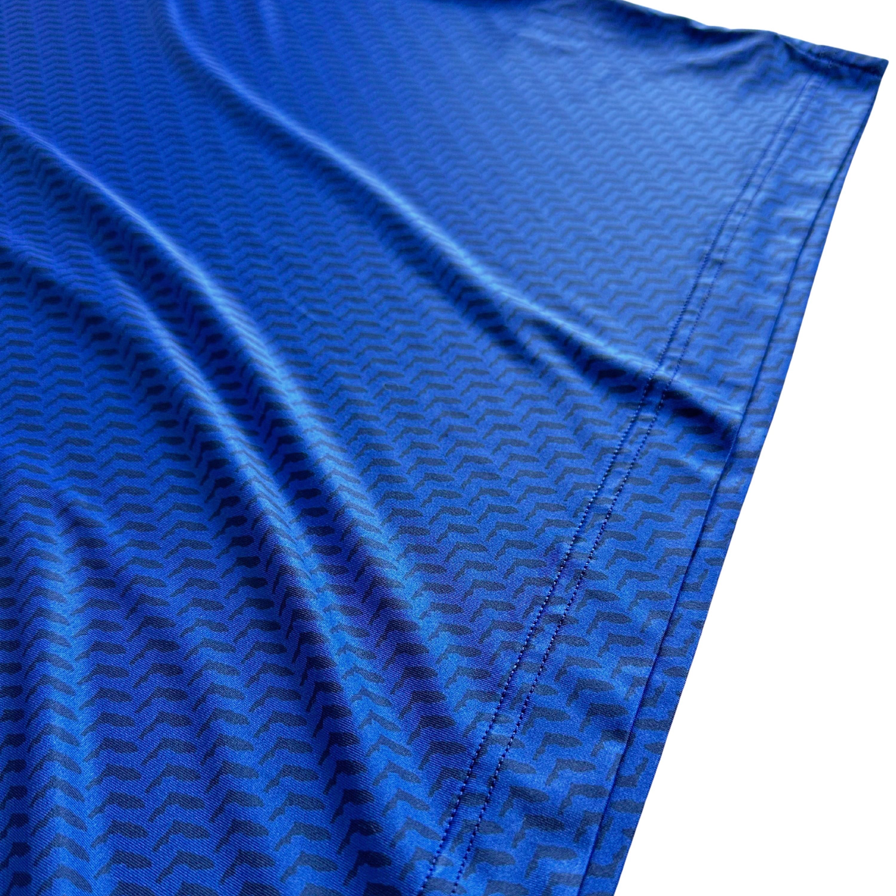 Close-up of blue fabric with a subtle pattern on a white background