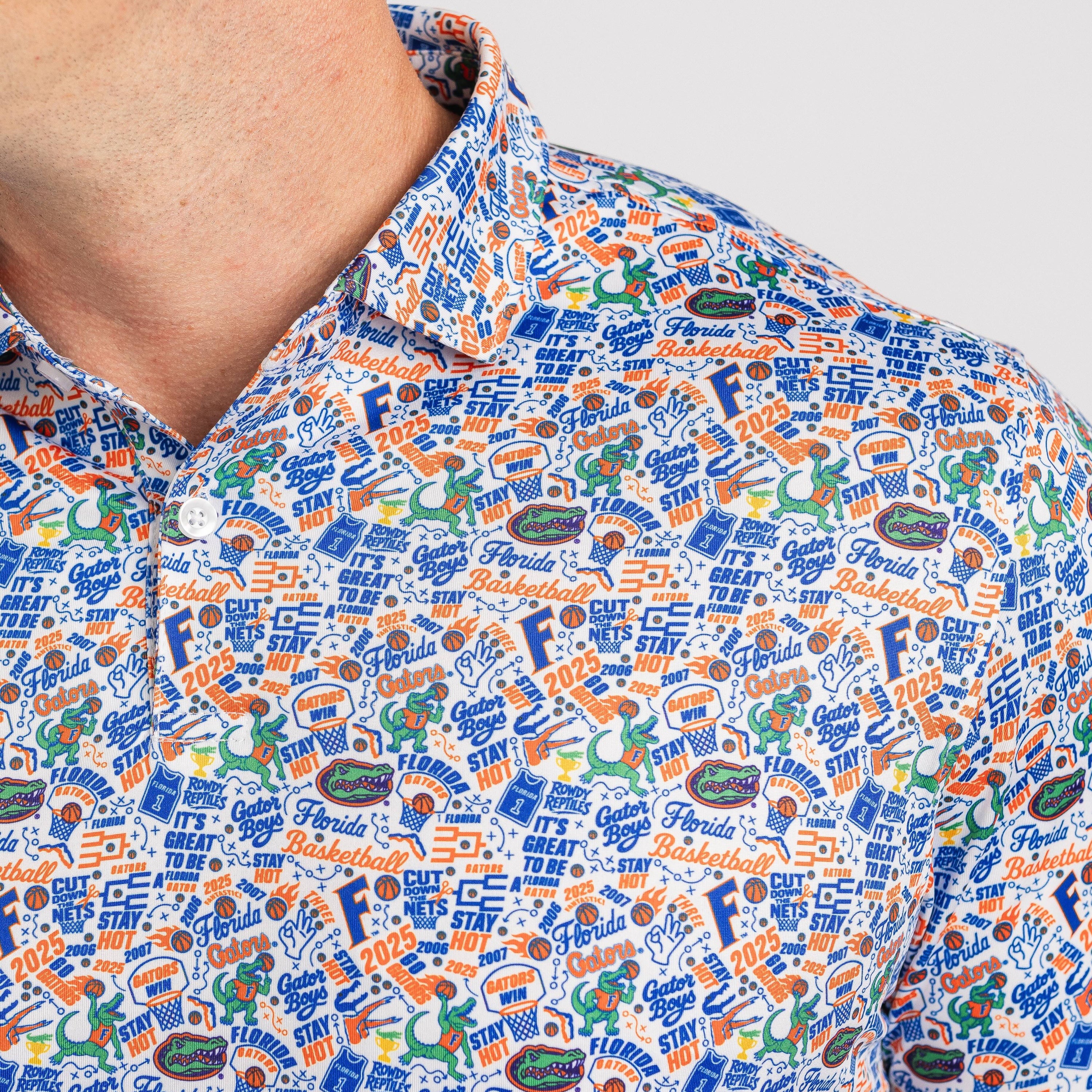 Close-up of a patterned shirt with various logos and text on a plain background