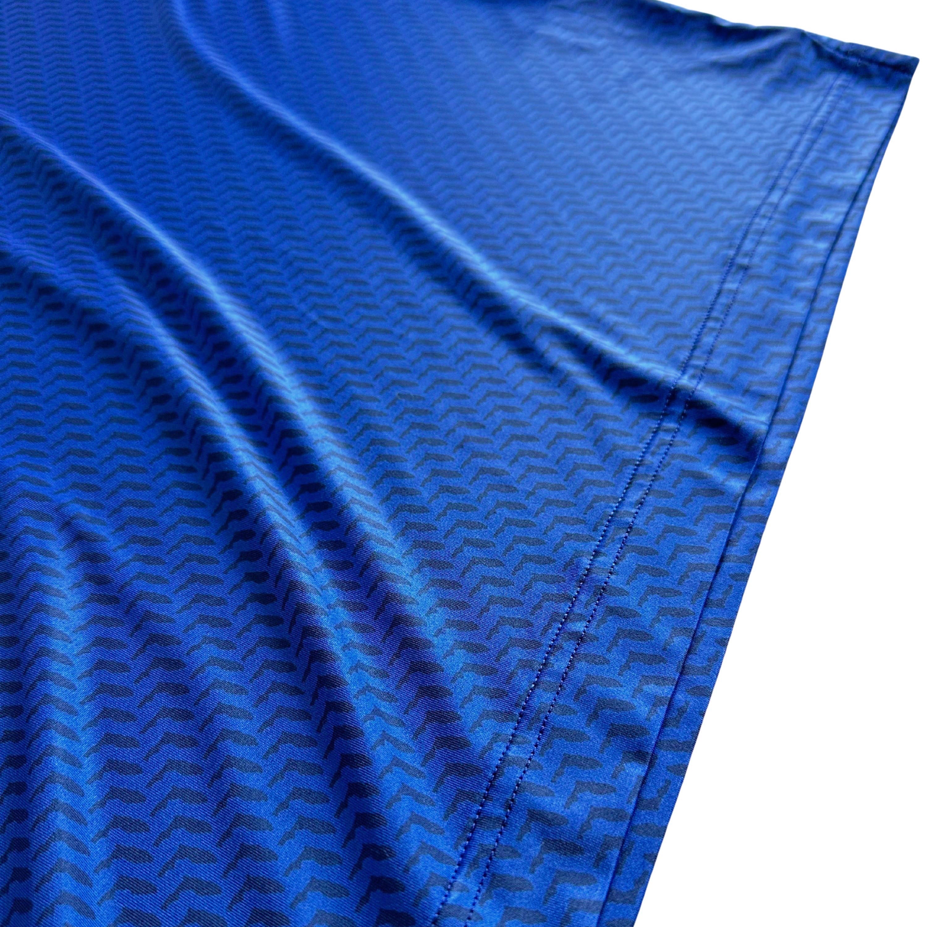 Close-up of blue fabric with a subtle pattern on a white background