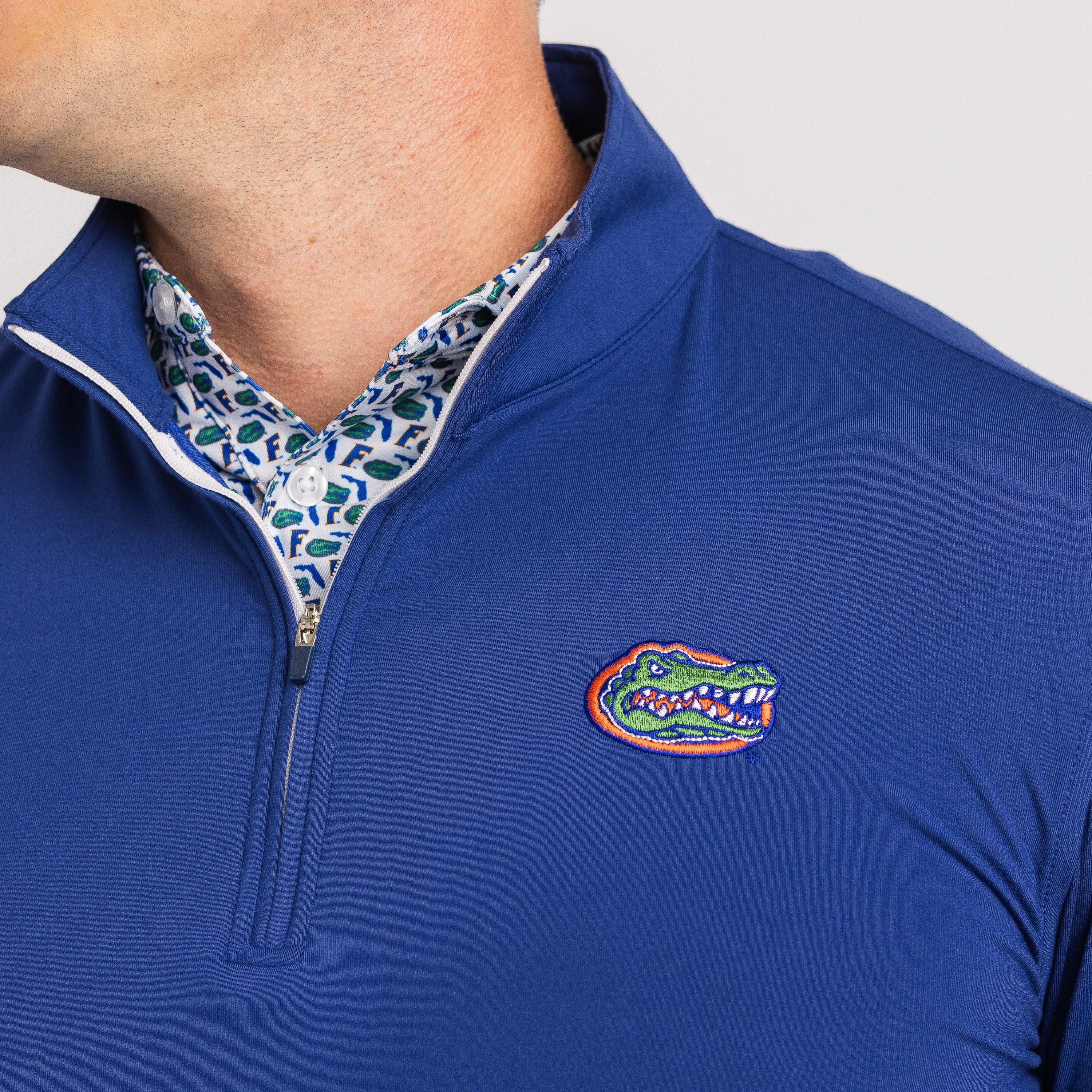 Zip-up with a logo on the chest against a gray background