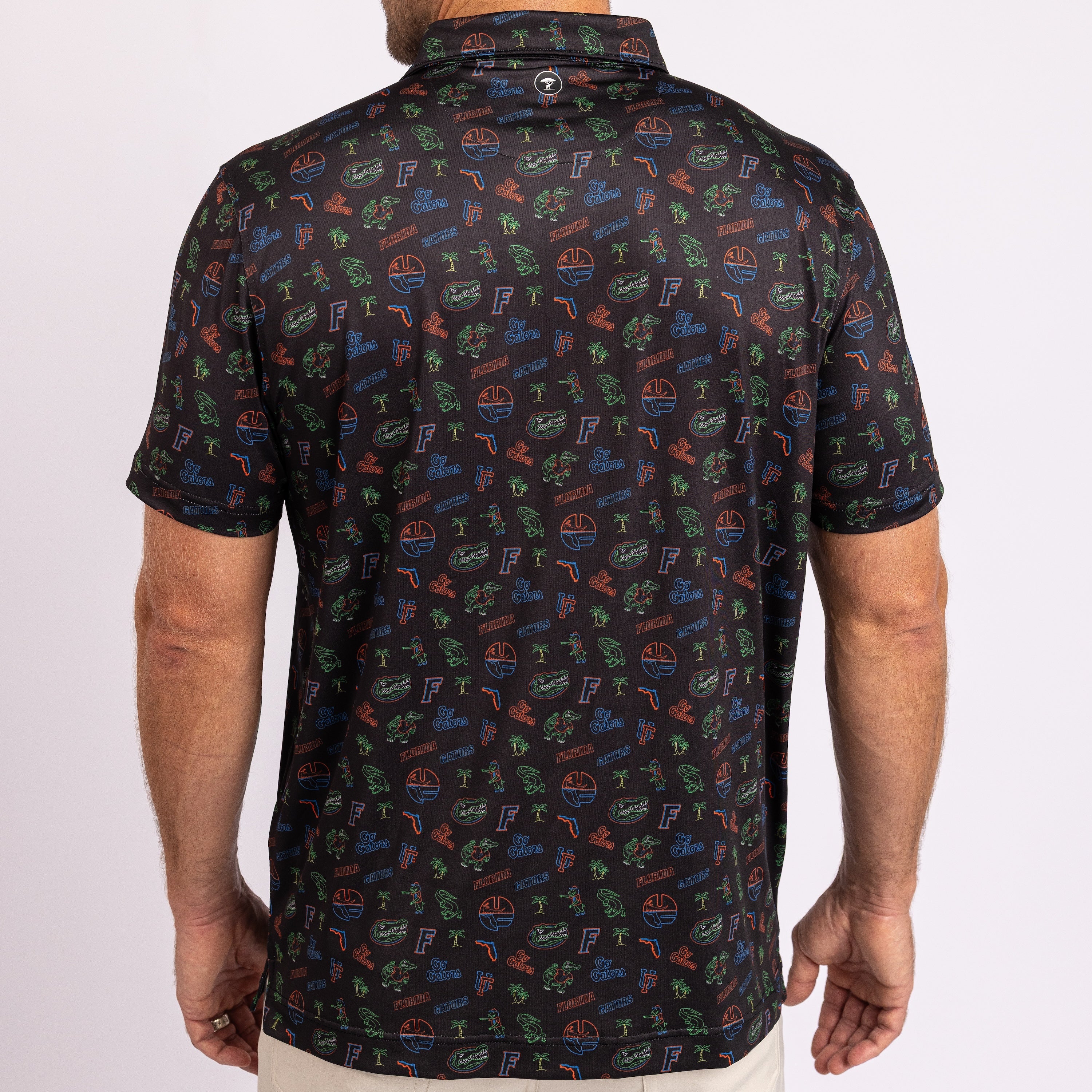 A man wearing a short-sleeve polo shirt from the back, featuring an all-over repeating pattern of the Florida logo in green, orange, and blue on a black background.
