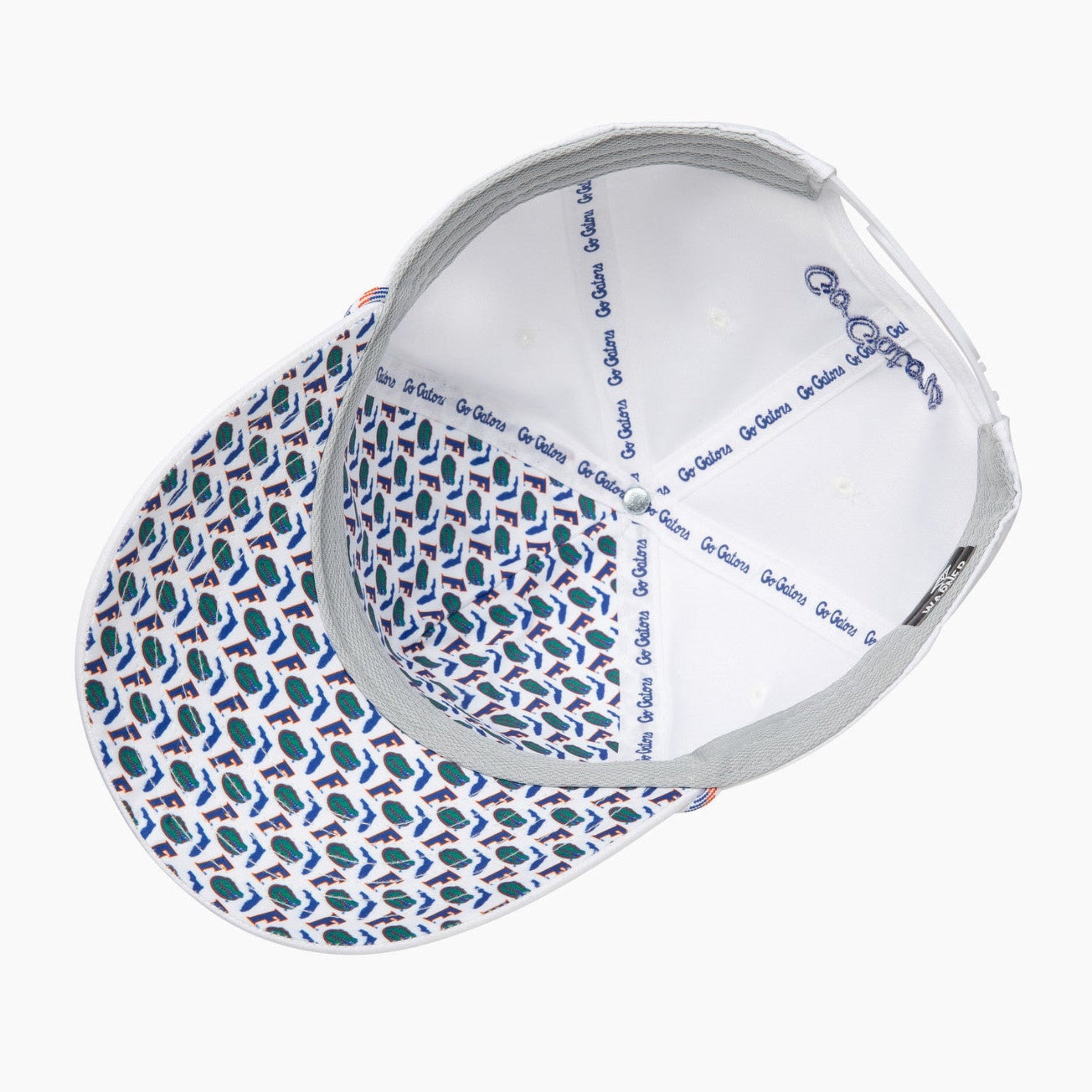 A top-down view of a baseball cap with a white interior and a blue and white geometric patterned brim, shown on a light gray background.