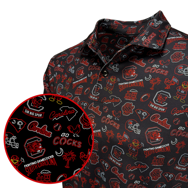 A close-up of a black polo shirt with an all-over red and white South Carolina Cocks themed graphic print, featuring a circular inset detail of the pattern.