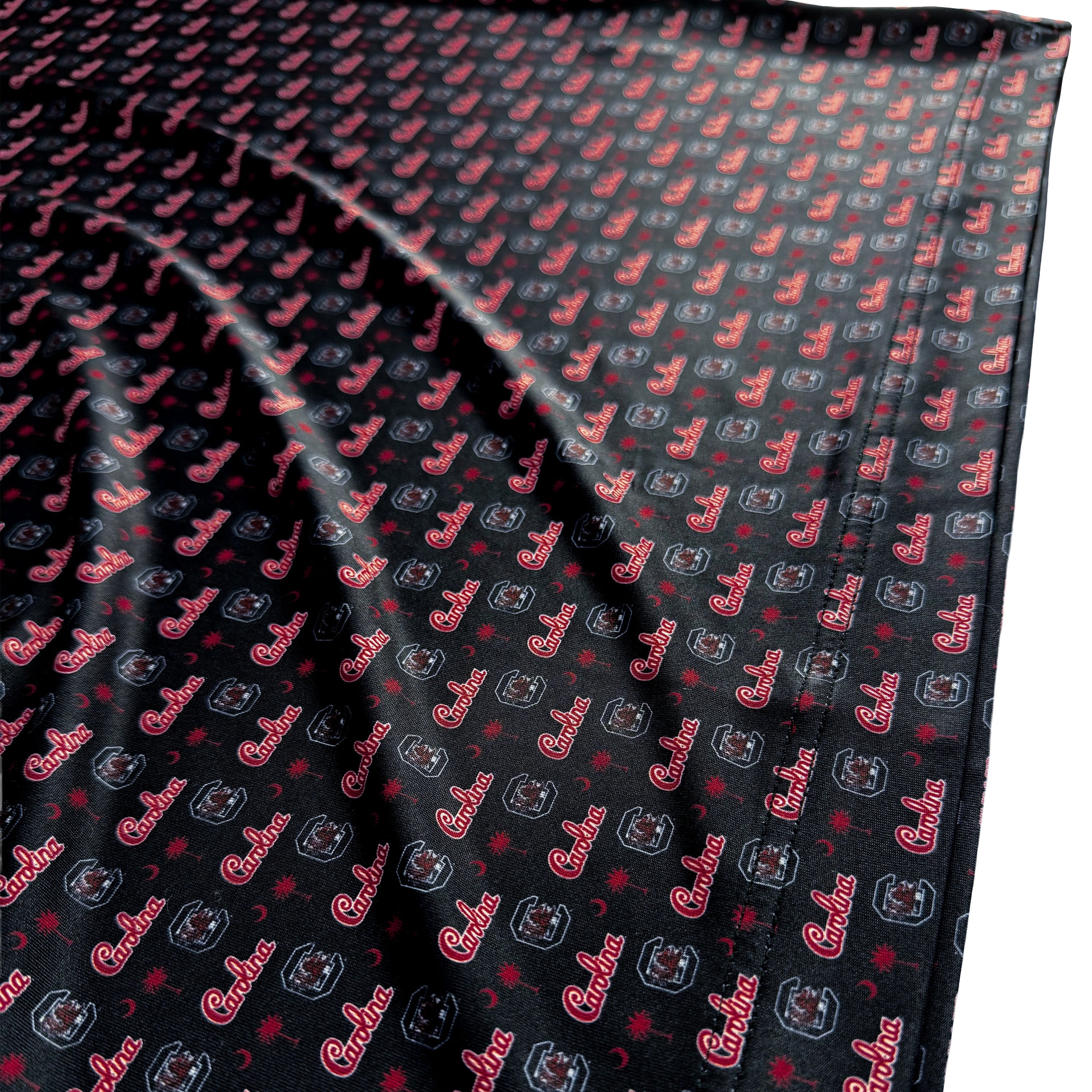 Black fabric with red and gray pattern, featuring text and shapes.