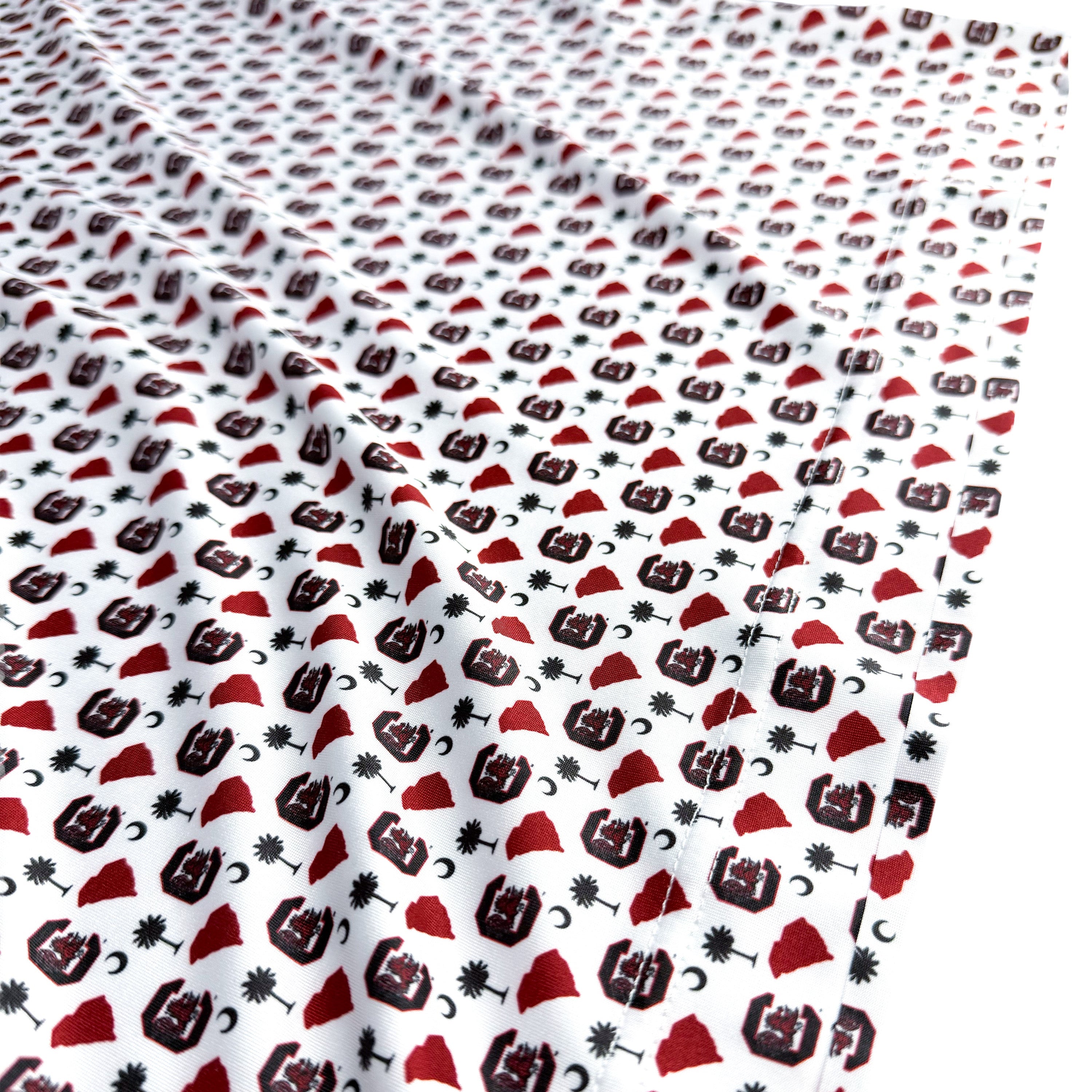 Fabric with a pattern of red and black shapes on a white background