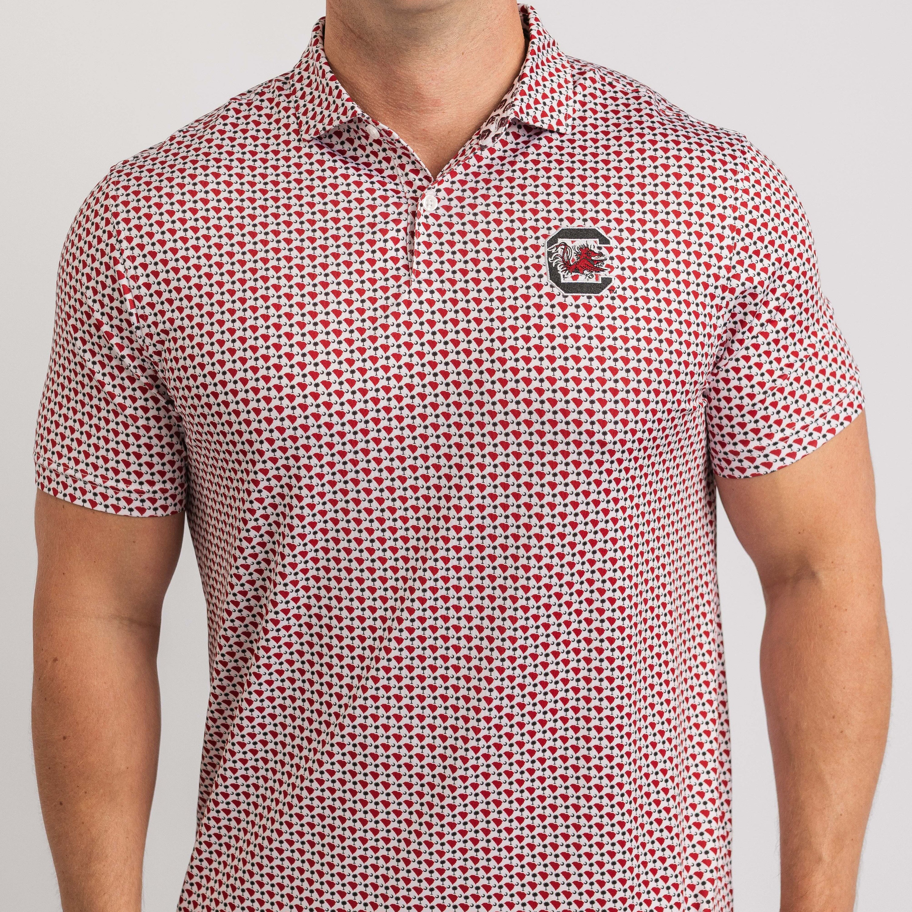 Man wearing a red and white patterned polo shirt with a logo on a gray background