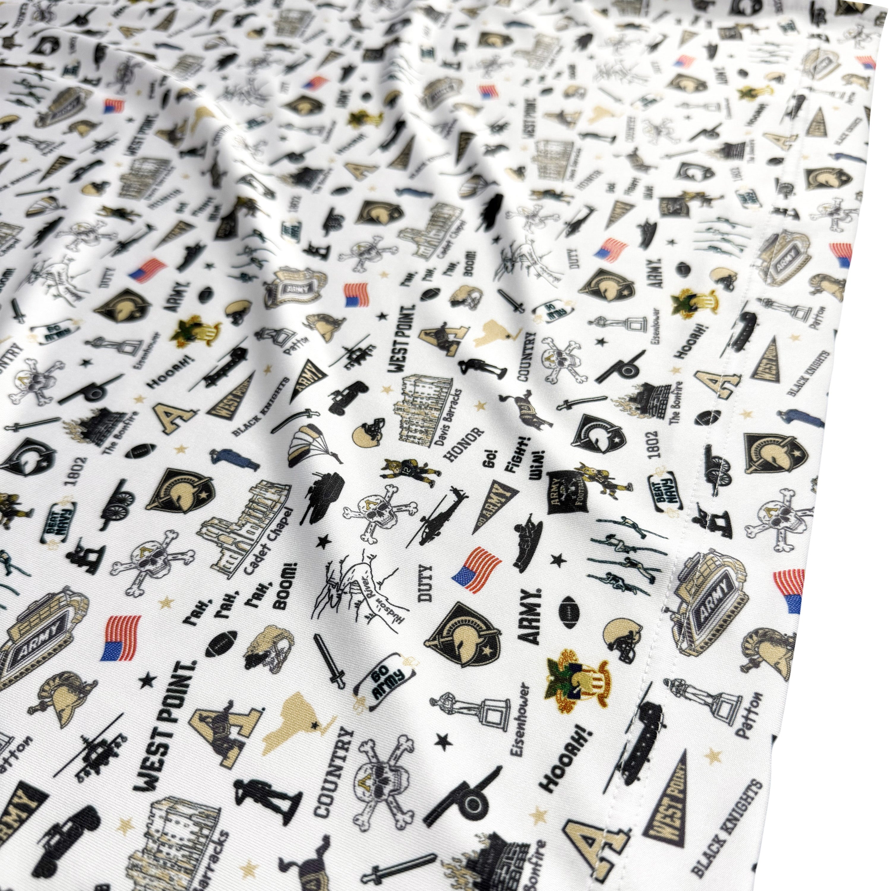 A close-up of a white fabric with an all-over collegiate and sports-themed graphic print featuring black, gold, and blue illustrations and text.