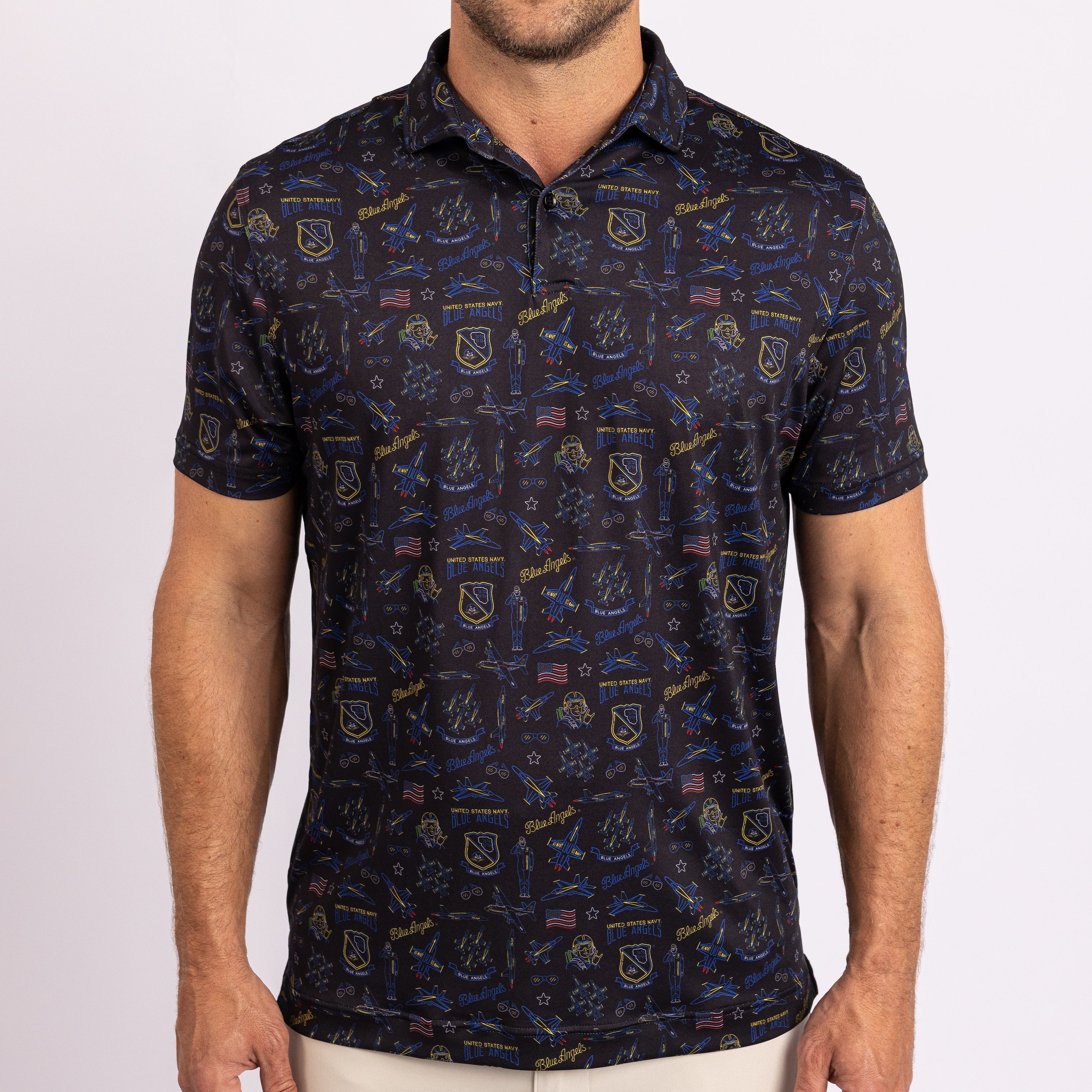 A man wearing a short-sleeve polo shirt with an all-over navy blue and gold nautical-themed pattern, including ships, anchors, and flags.