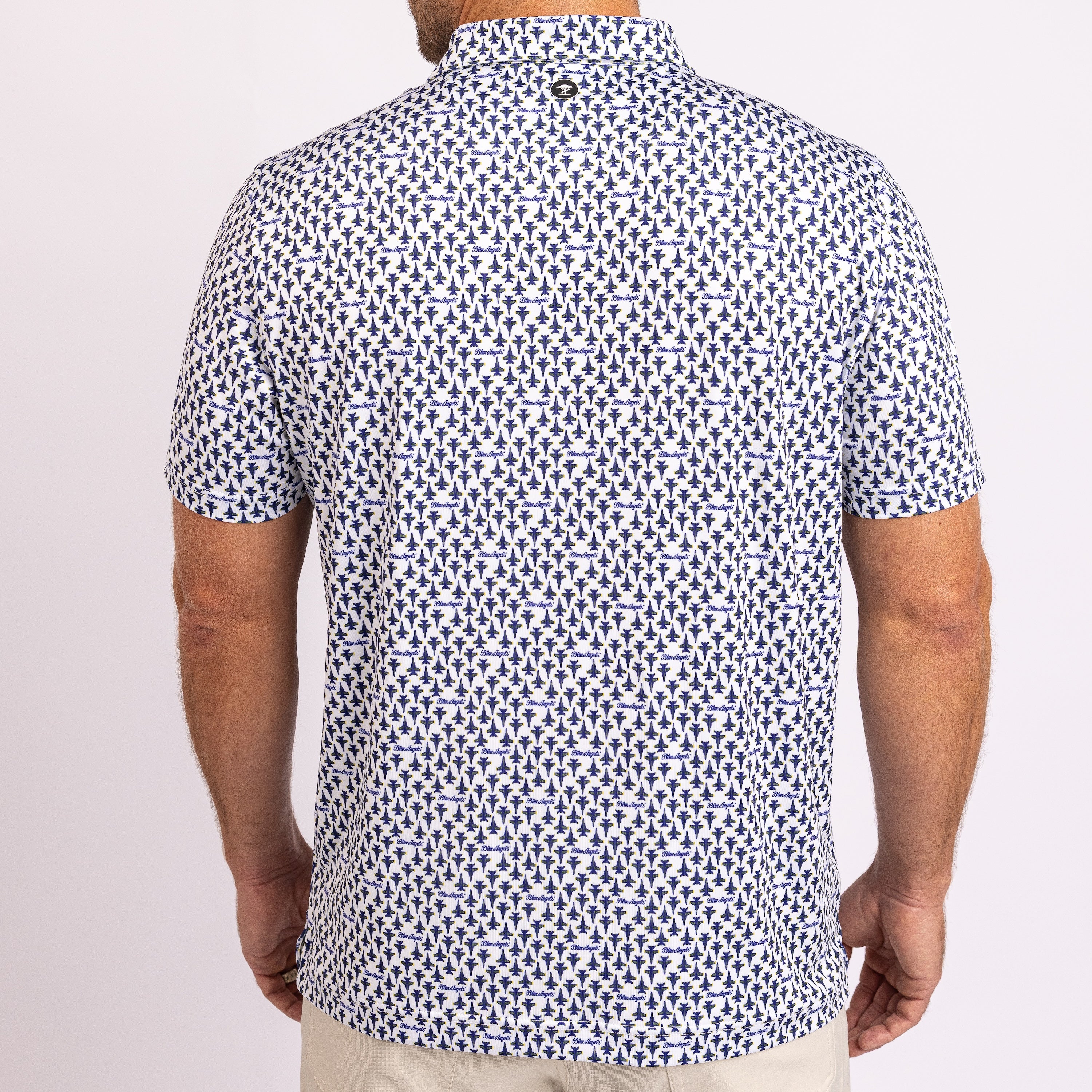 A man wearing a short-sleeve button-up shirt with a blue and white geometric pattern, shown from the back against a plain light background.