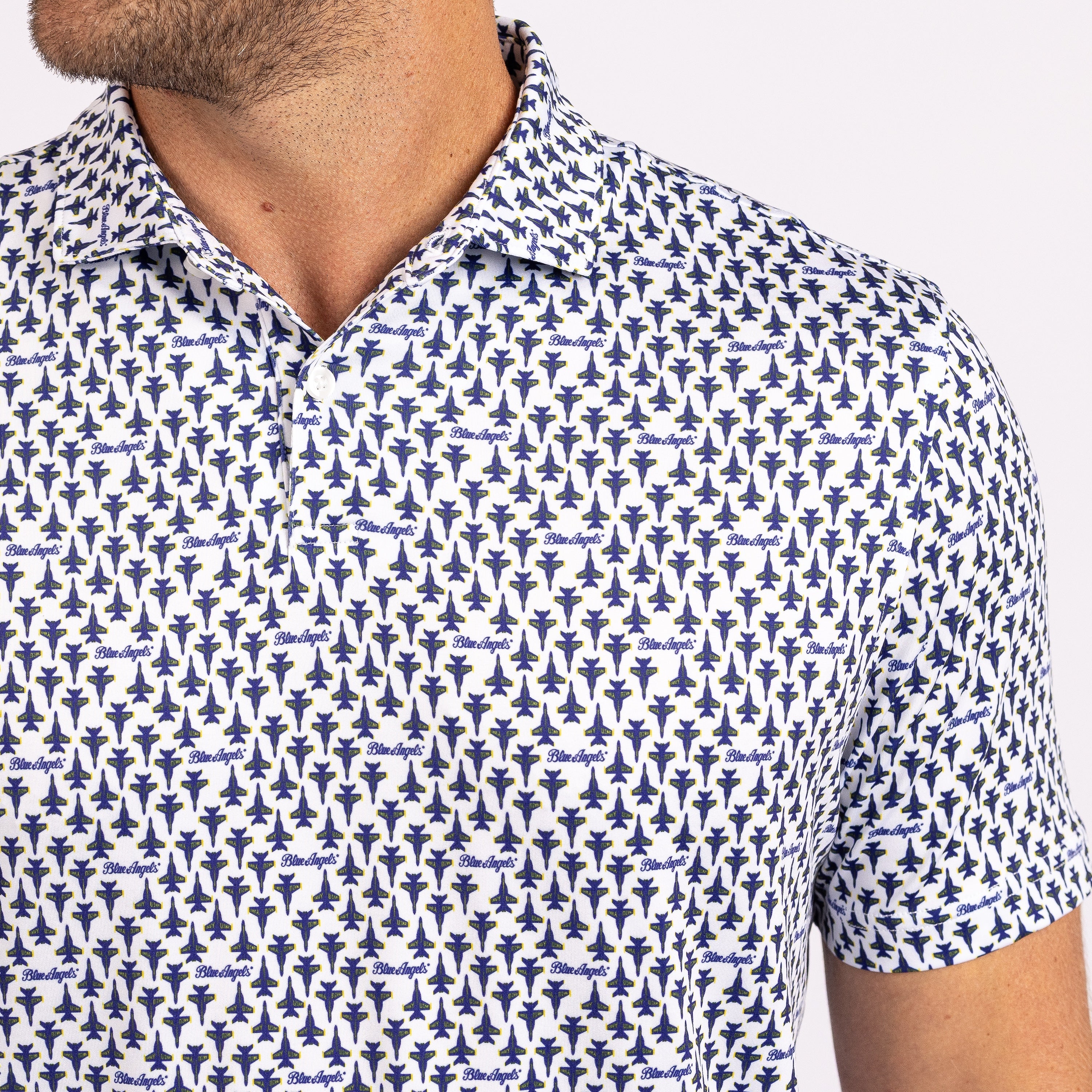 Close-up of a man wearing a short-sleeve polo shirt with a repeating blue and white abstract pattern.