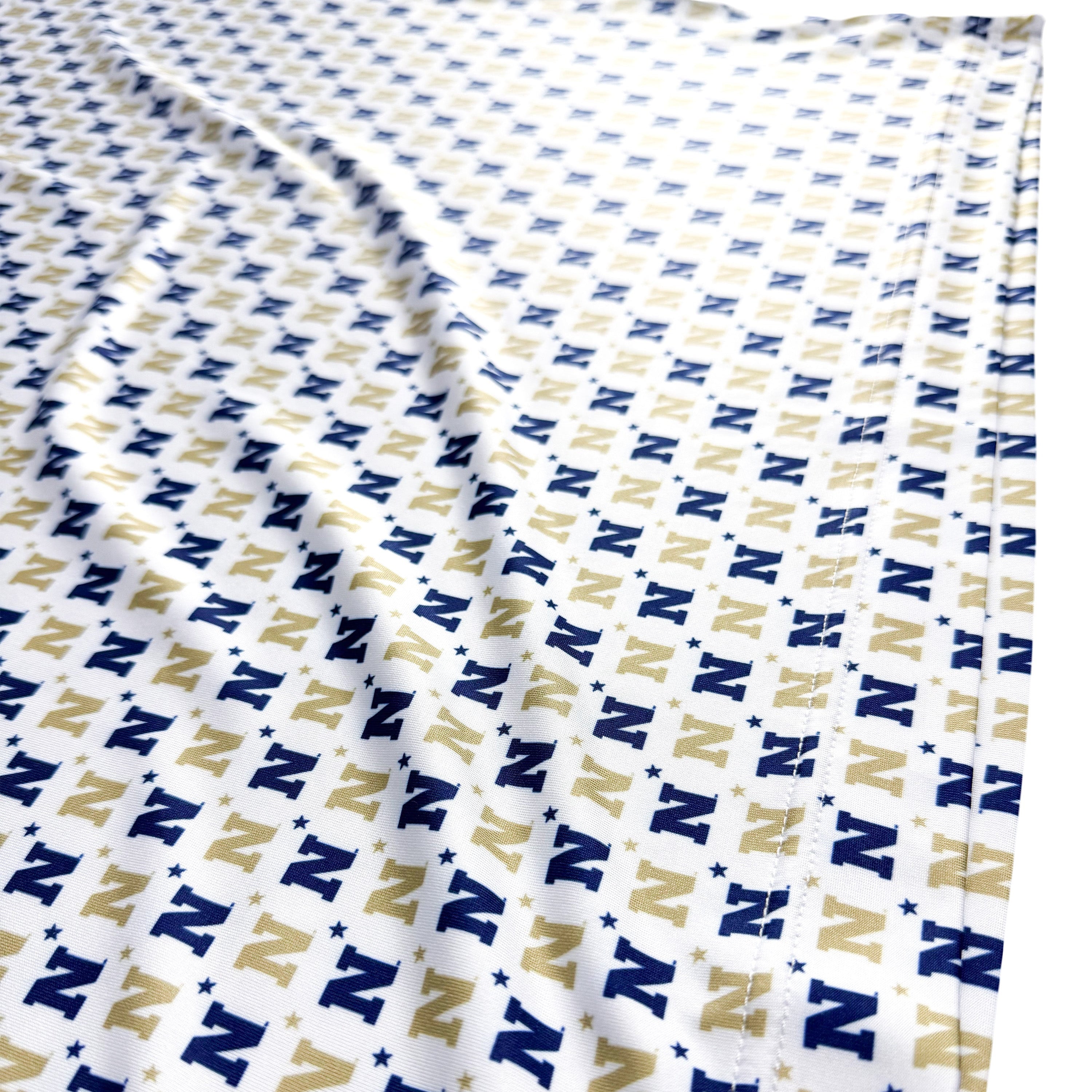 Folded fabric with a pattern of 'N' letters in blue and beige on a white background