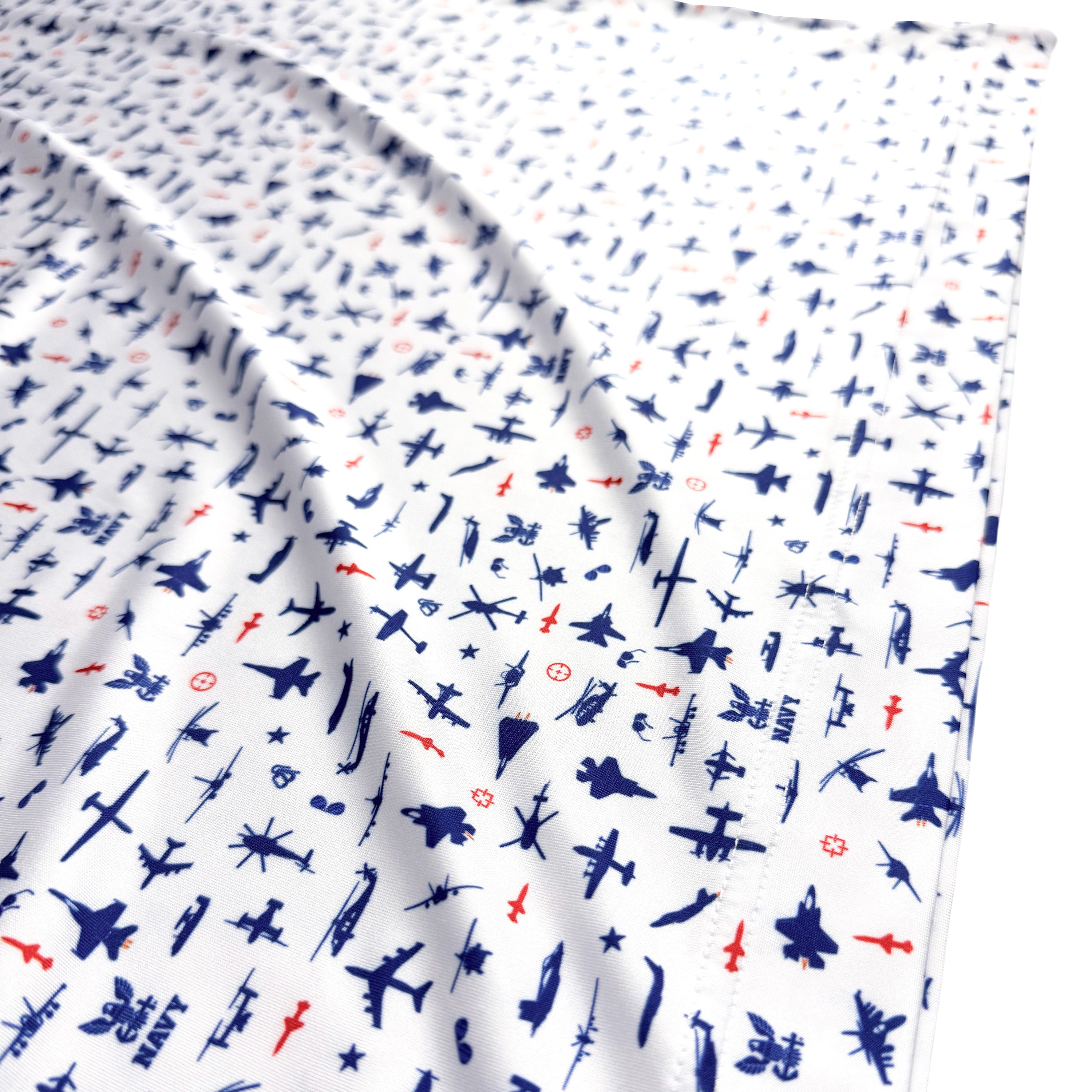 Fabric with airplane pattern in blue, red, and black on a white background