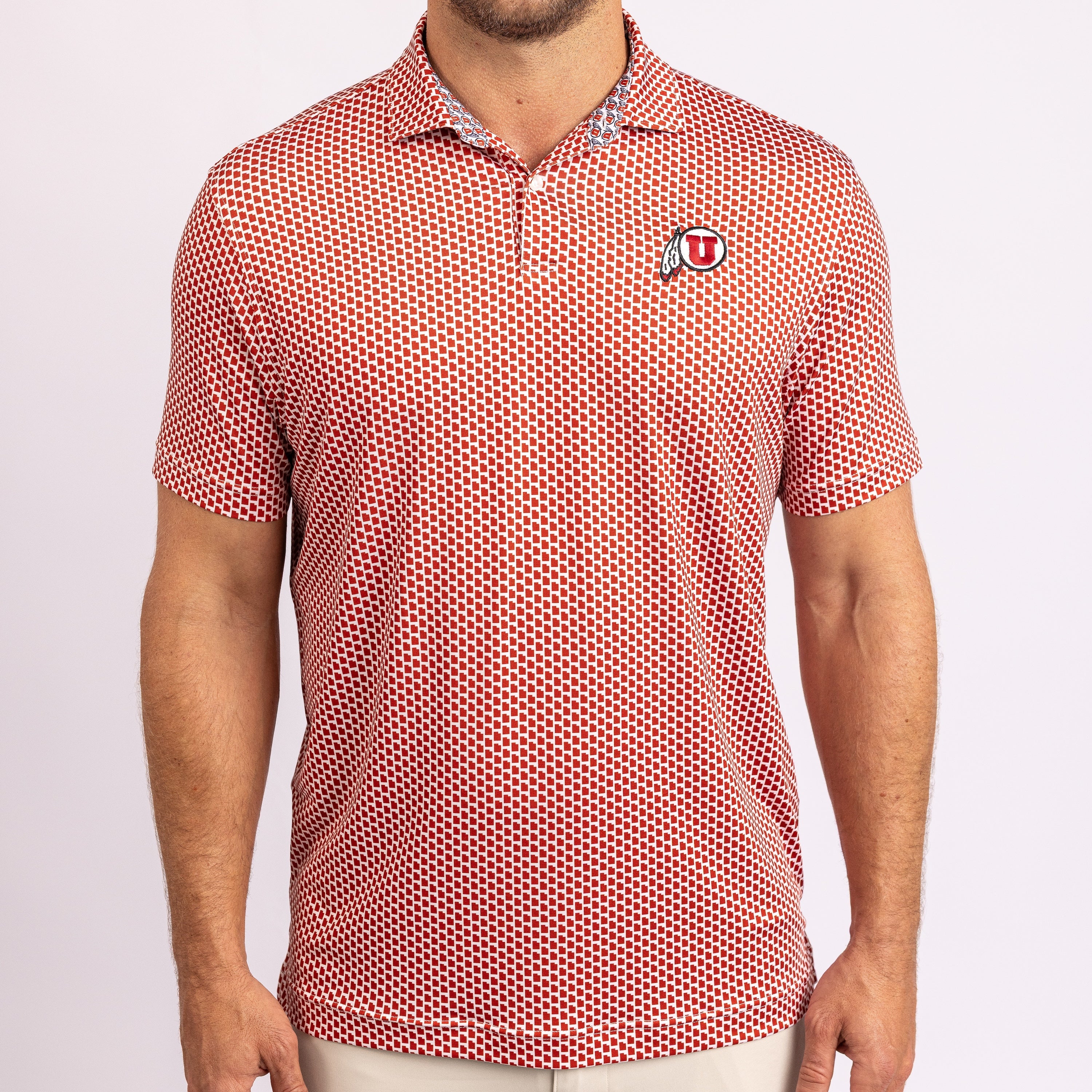 A man wearing a short-sleeve polo shirt with a red and white micro-dot pattern and a small Utah U logo on the left chest, photographed against a light gray studio background.